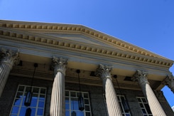 A building with columns and a clock on the front of it