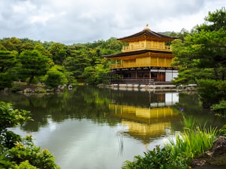 A golden building sitting on top of a lush green forest