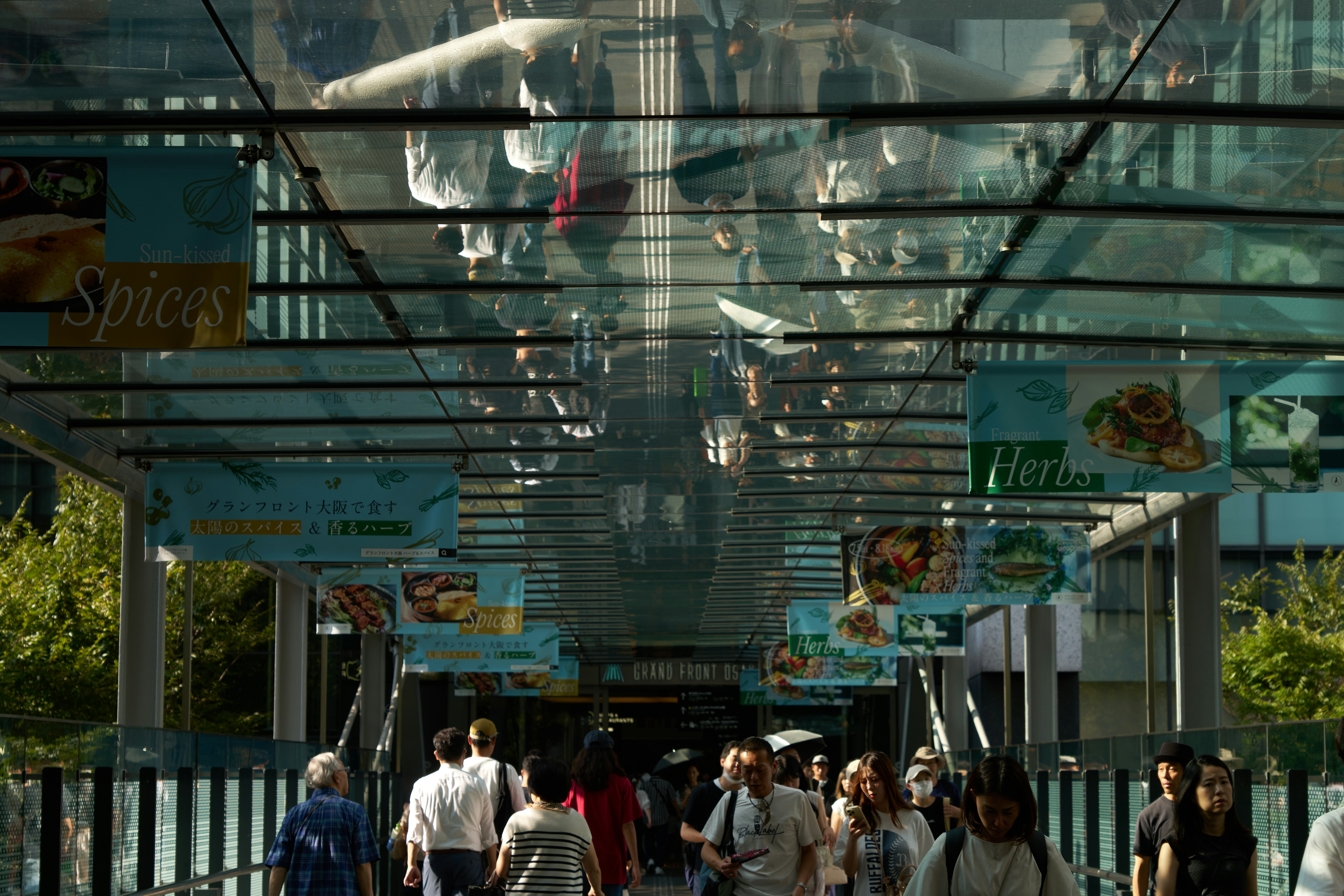 A group of people walking down a street next to tall buildings