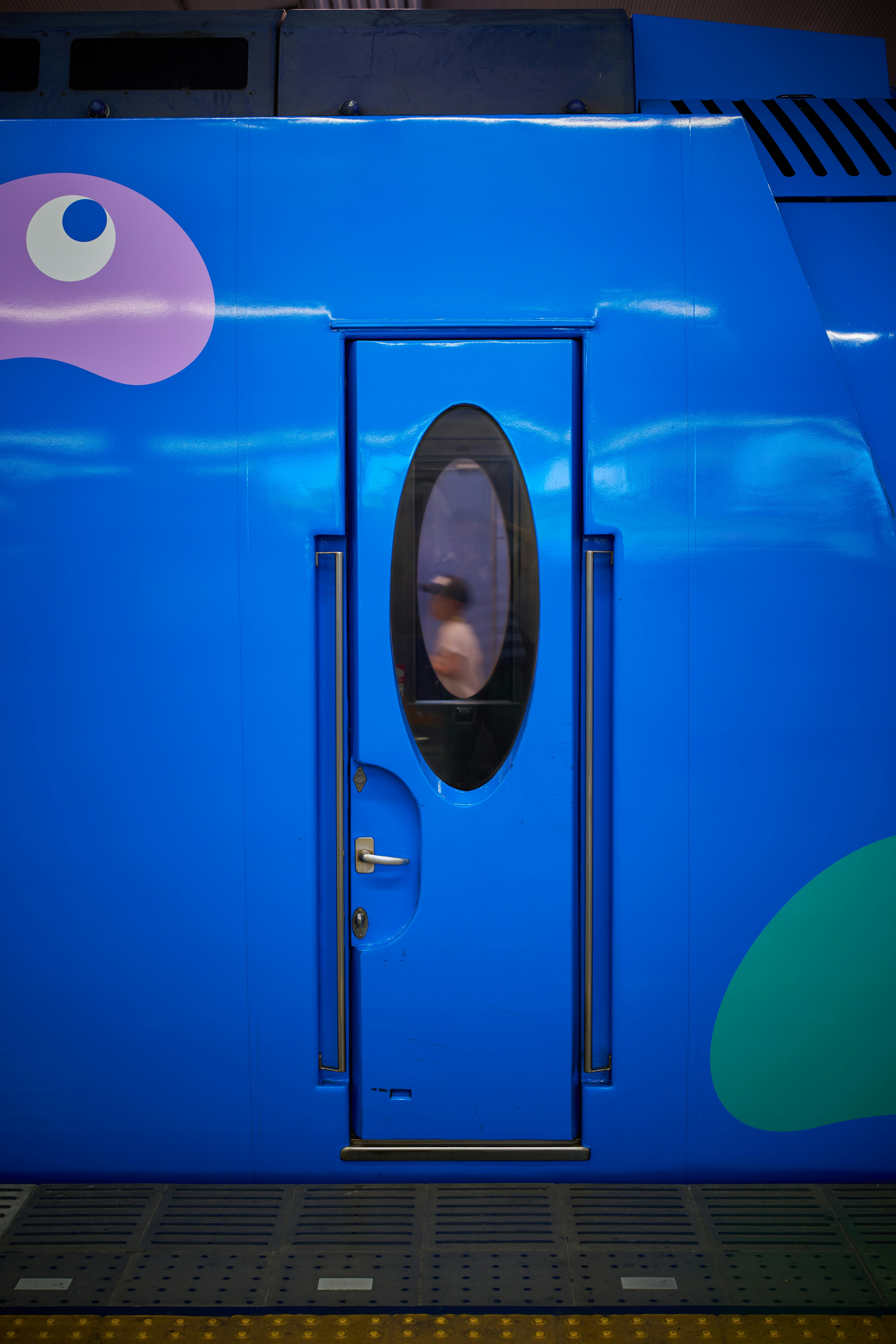 A blue train with a toilet in the middle of it