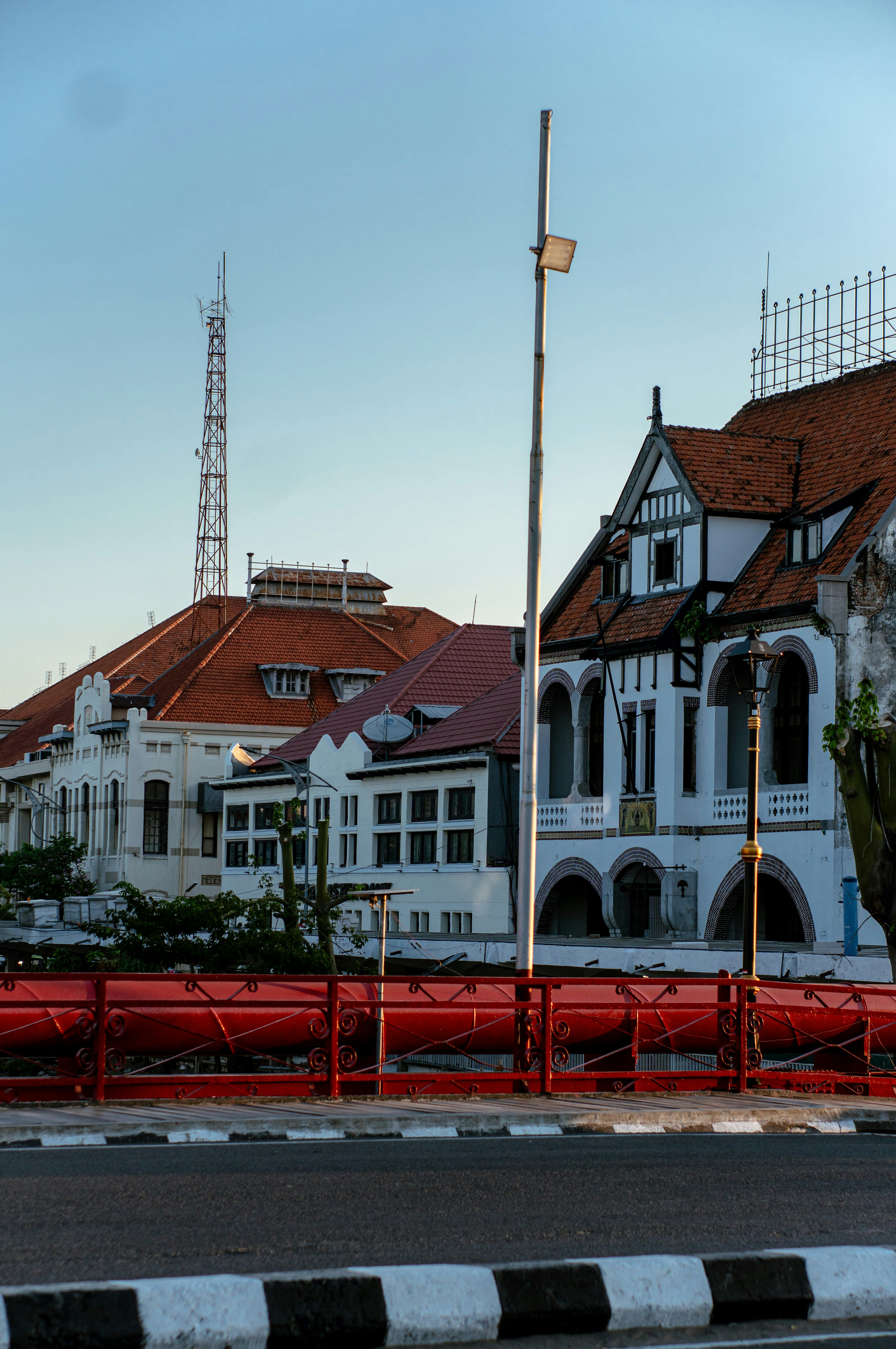 Sebuah bangunan putih besar dengan pagar merah di sekelilingnya
