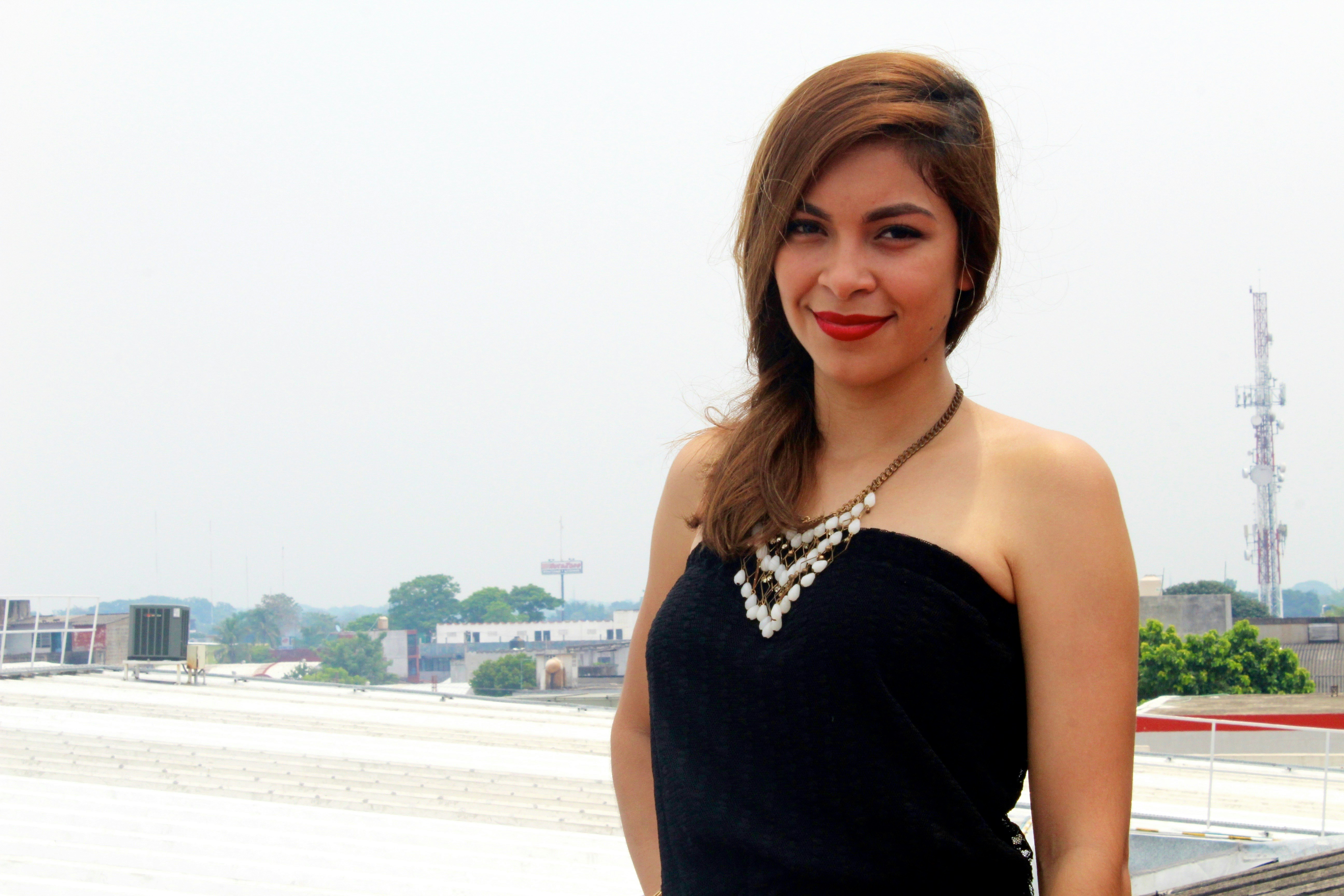 검은 드레스를 입은 여성이 사진을 찍기 위해 포즈를 취하고 있다