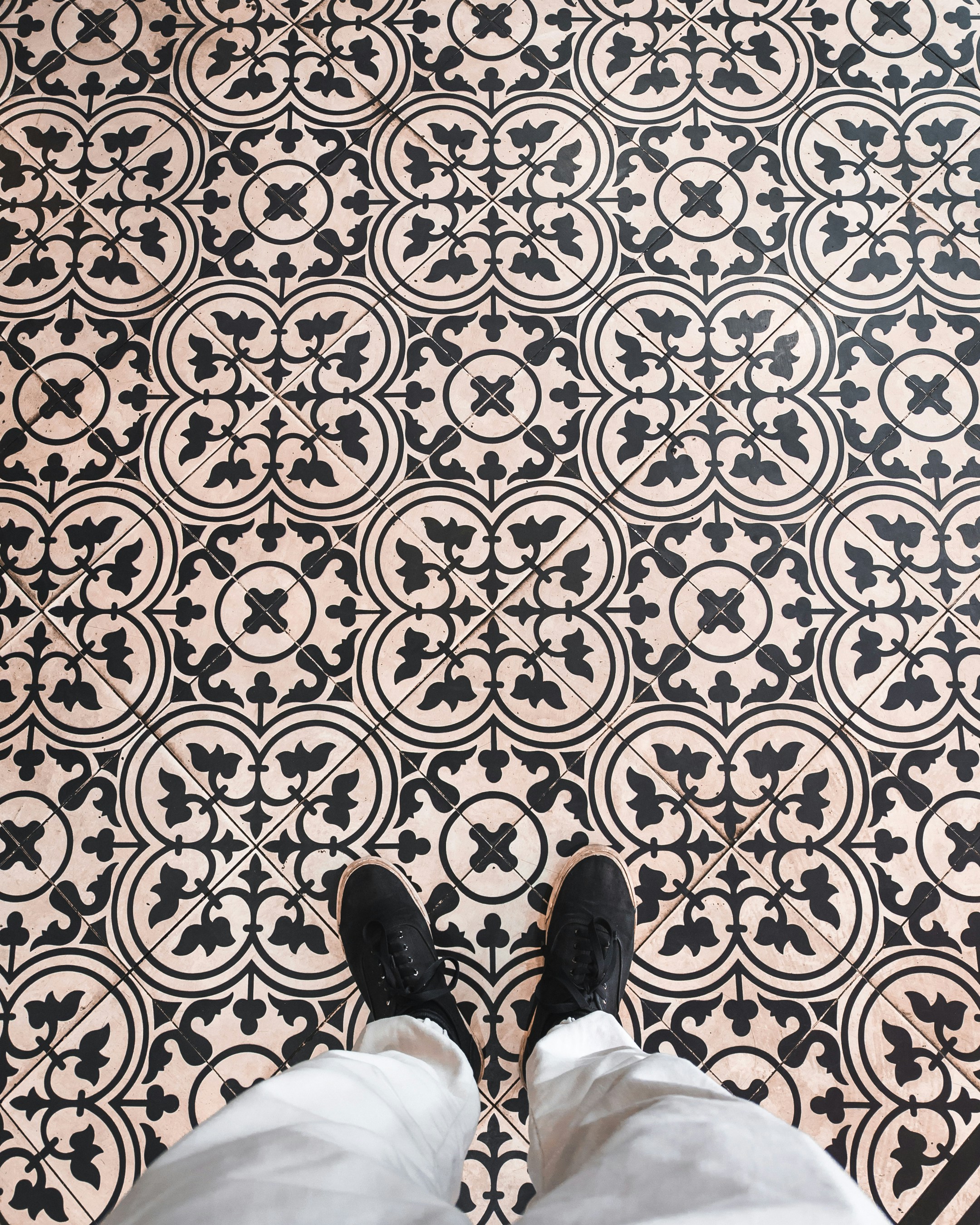 A person standing in front of a black and white tile floor