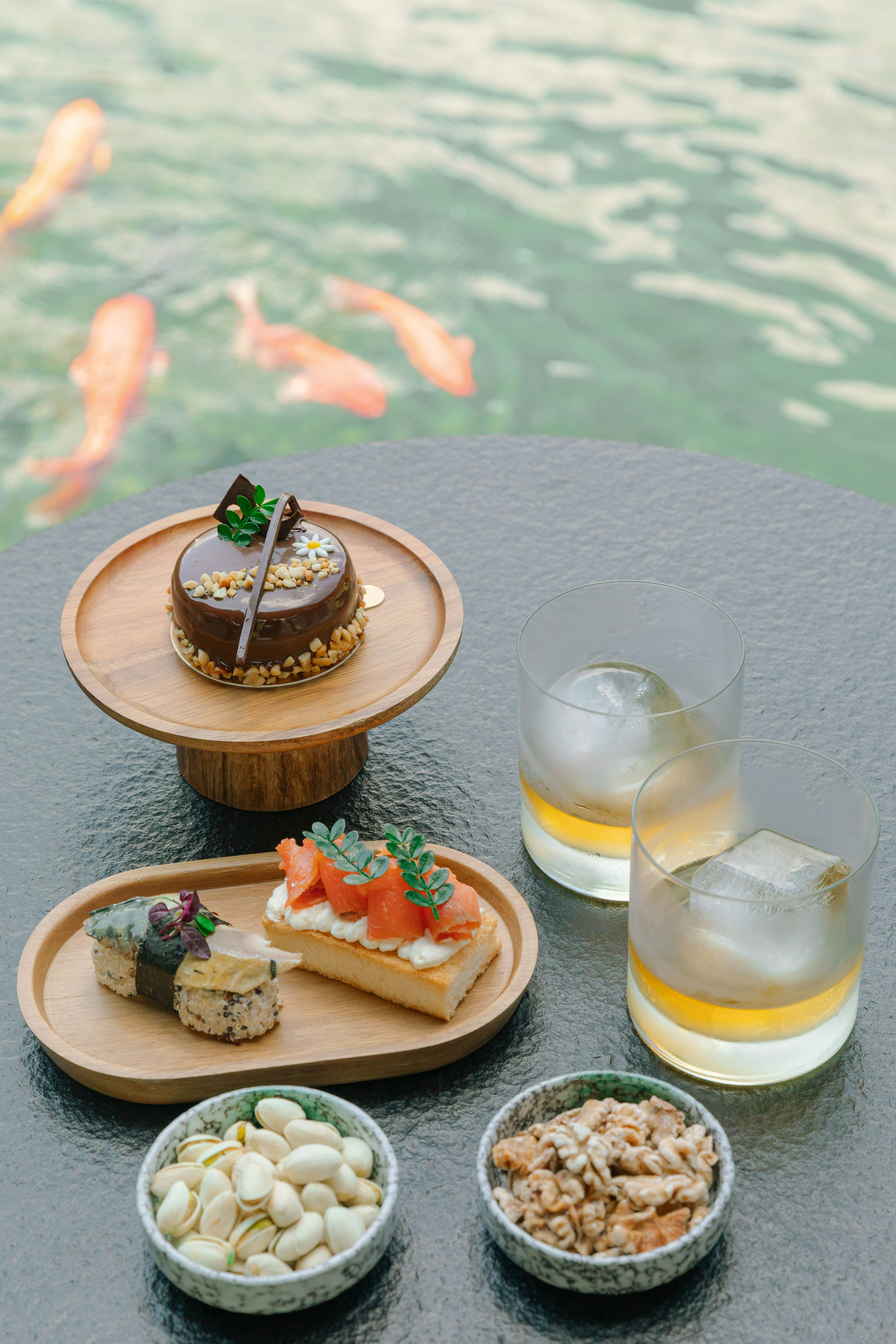 A table topped with plates of food next to a body of water