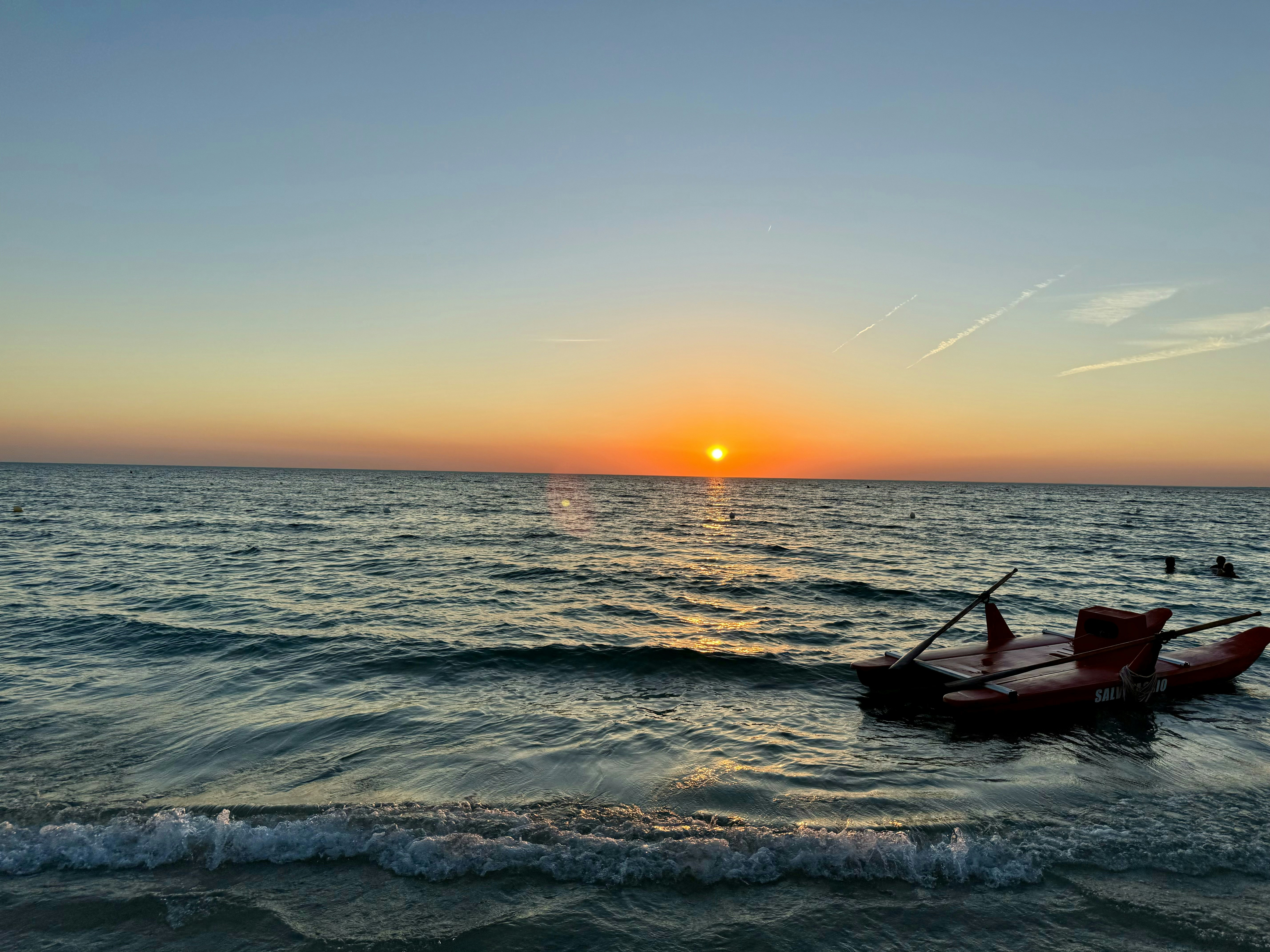 A small boat floating on top of a body of water