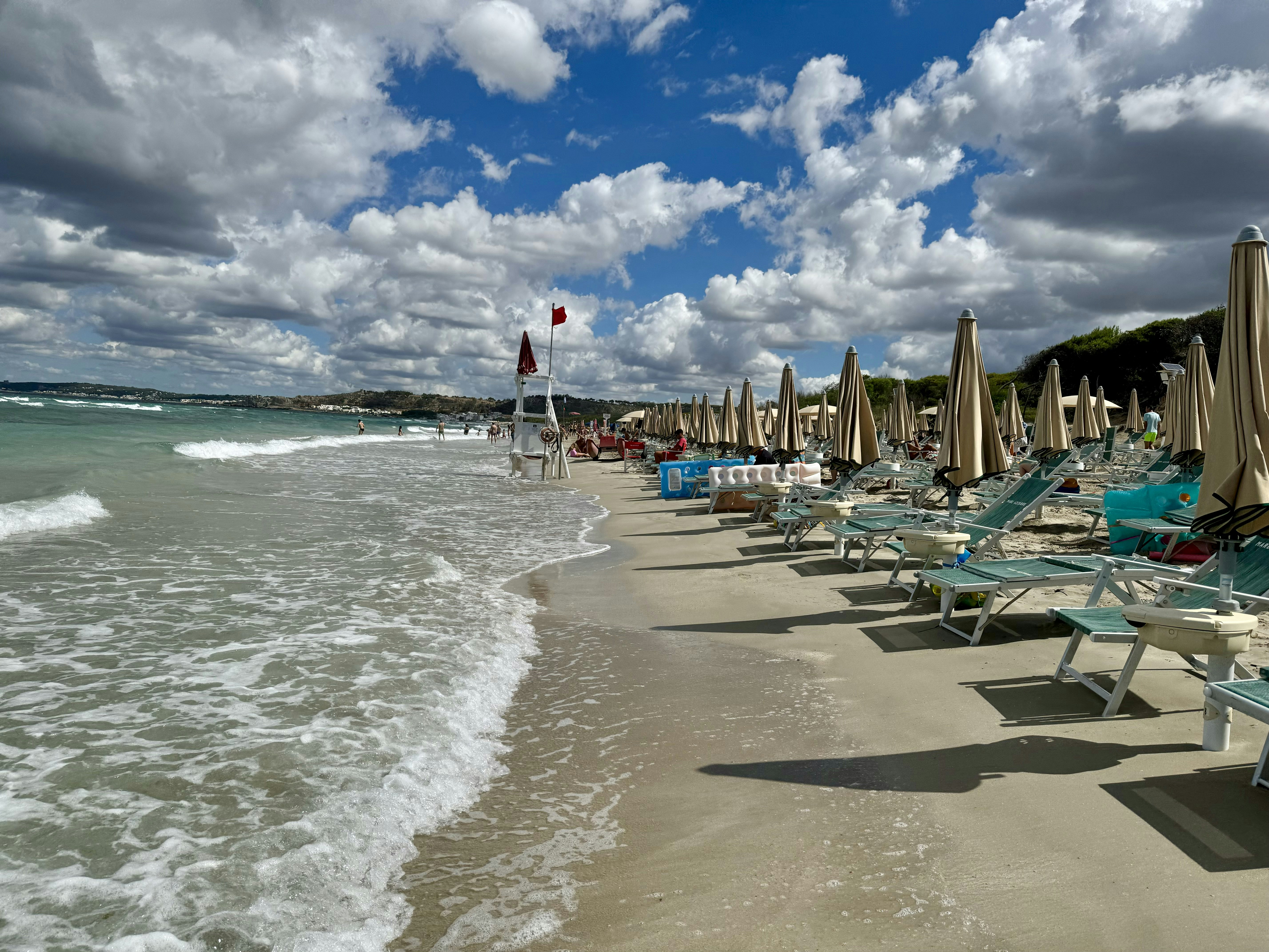 A row of beach chairs sitting on top of a sandy beach