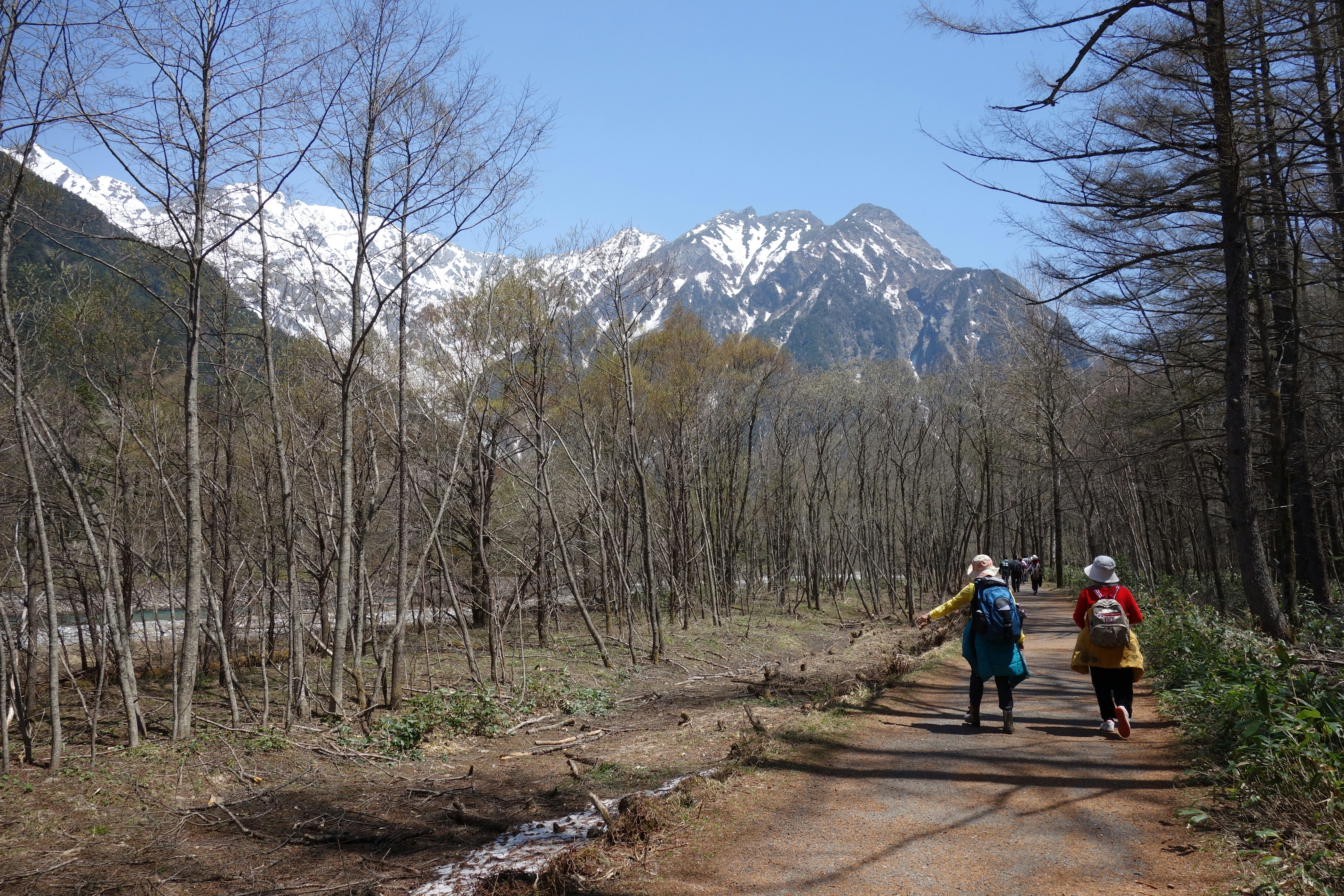 A group of people walking down a dirt road