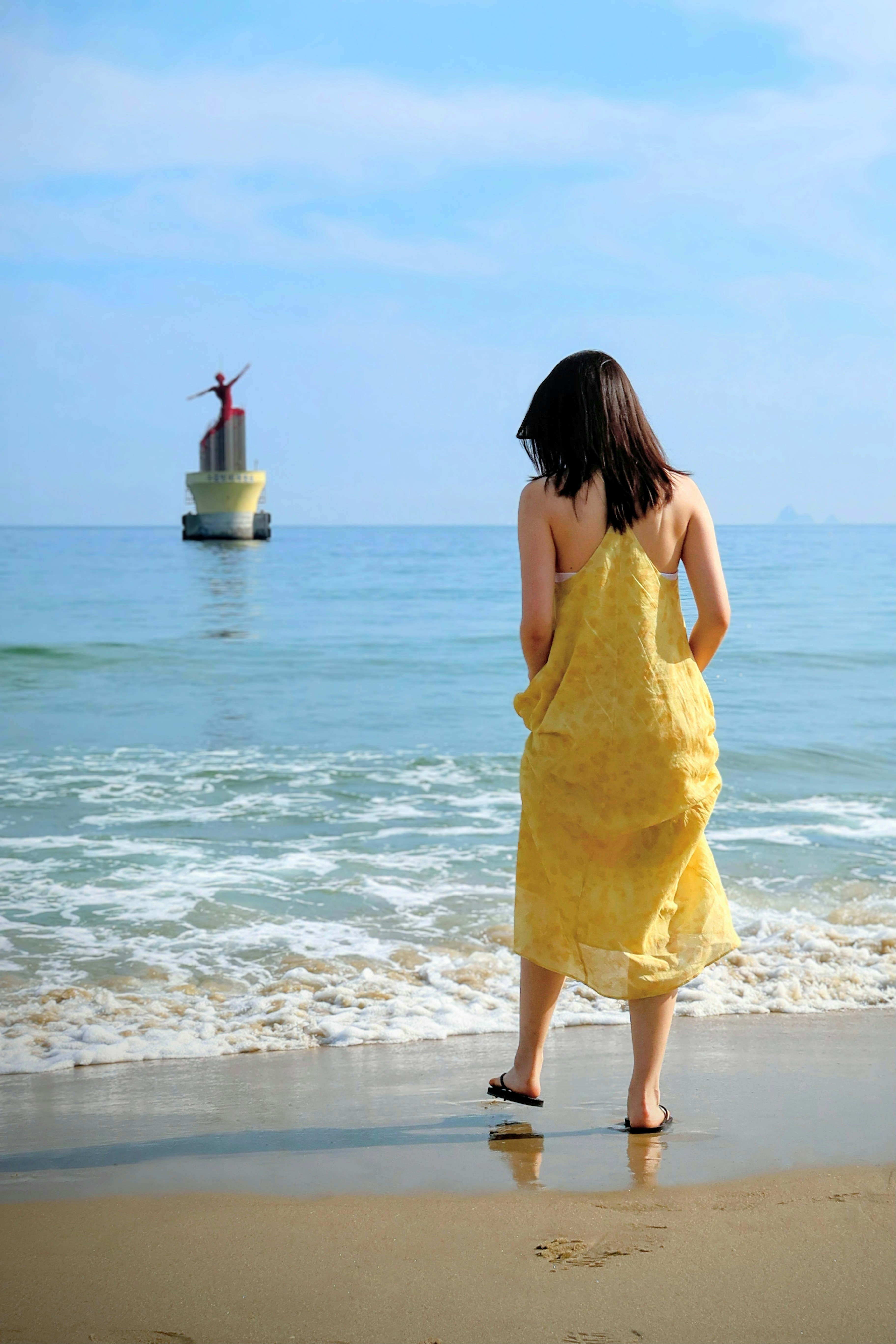 A woman in a yellow dress standing on a beach photo – Free Girl Image ...