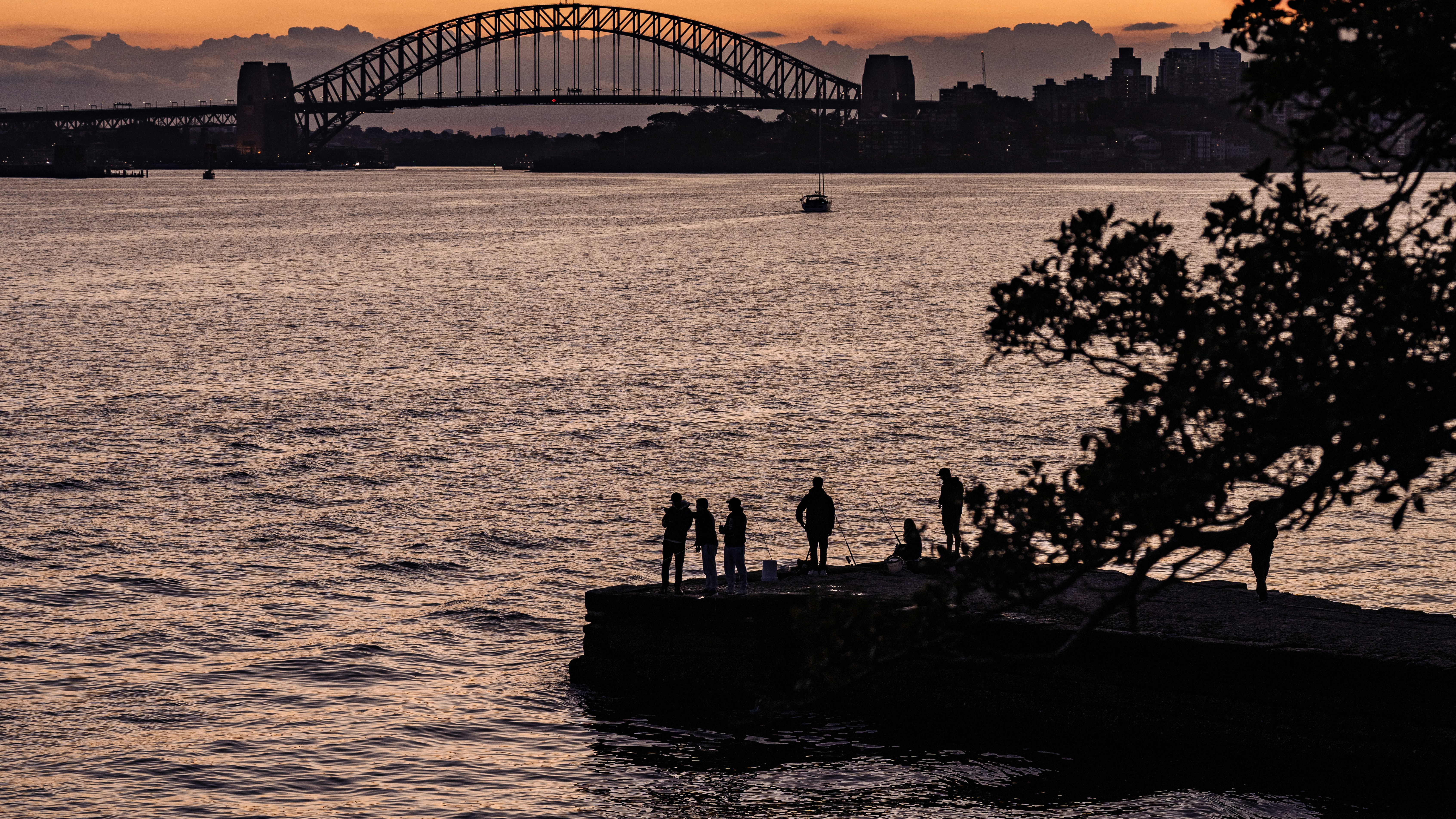 A group of people standing on the edge of a body of water