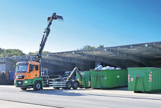 A crane is lifting a container onto a truck