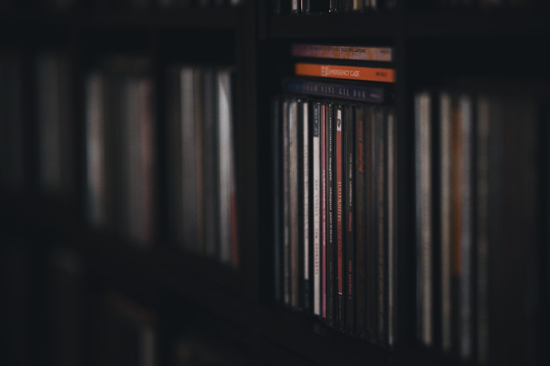 A book shelf filled with lots of books, Music CDs