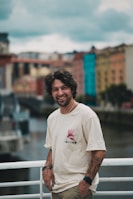 A man standing on a bridge next to a body of water