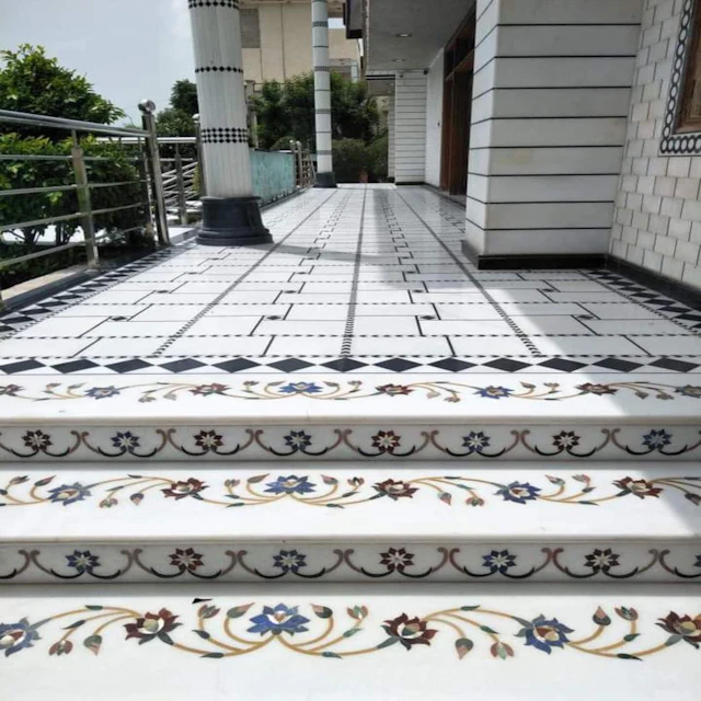 White marble steps with blue and gold floral inlay on the risers