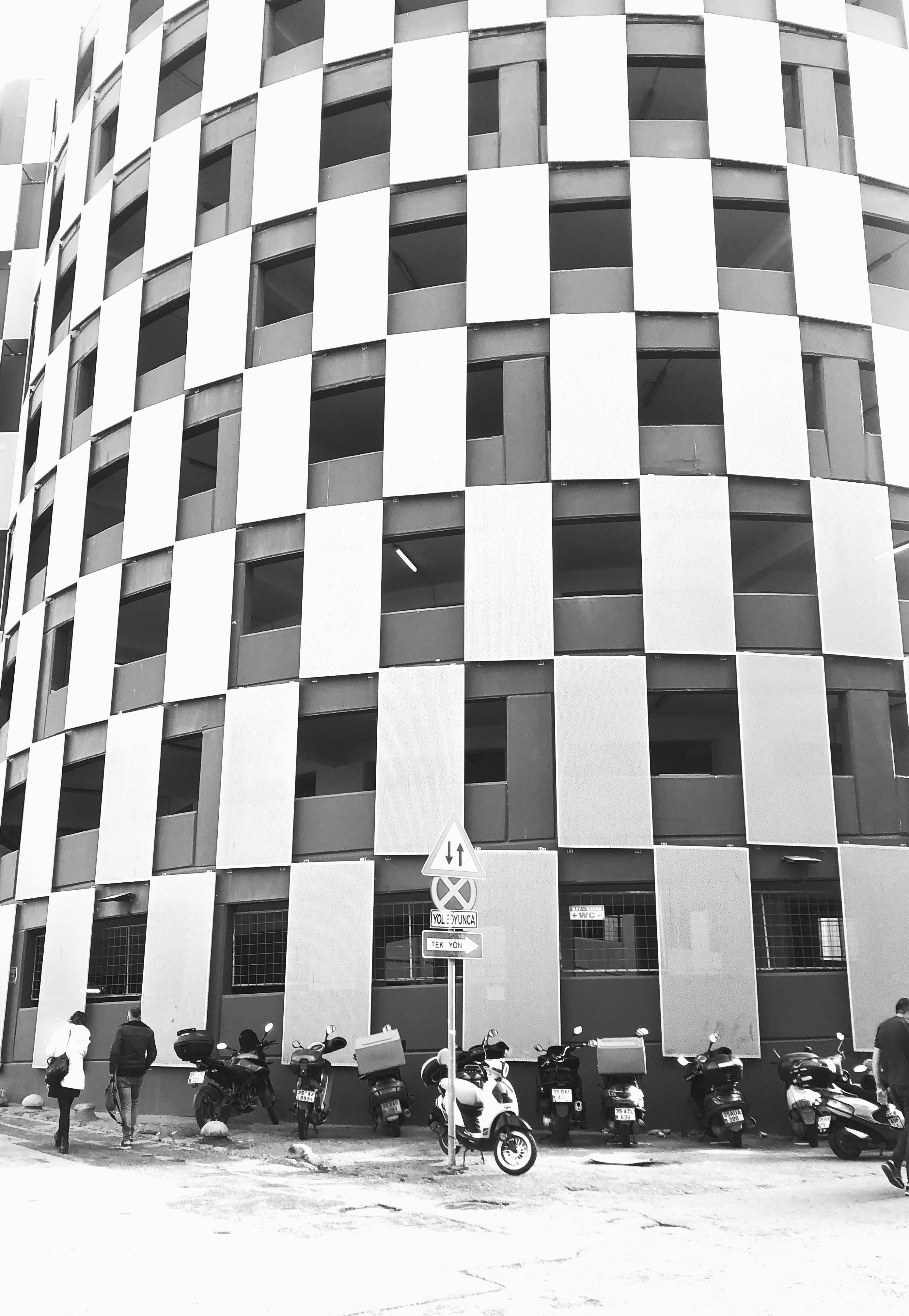 A black and white photo of a building with motorcycles parked in front of it