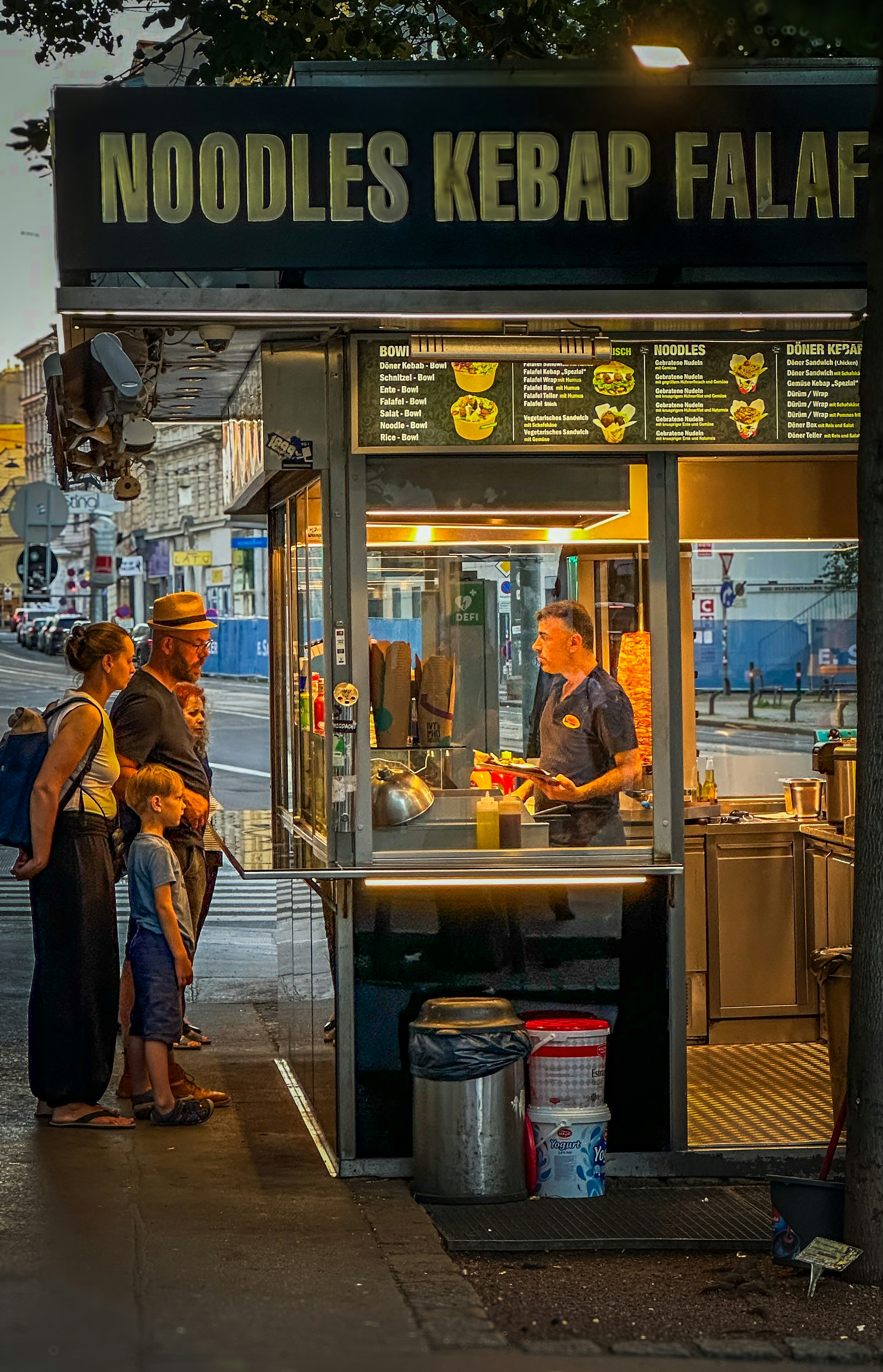 Eine Gruppe von Menschen, die vor einem Kiosk stehen