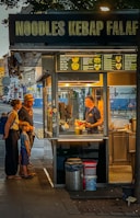 A group of people standing outside of a kiosk