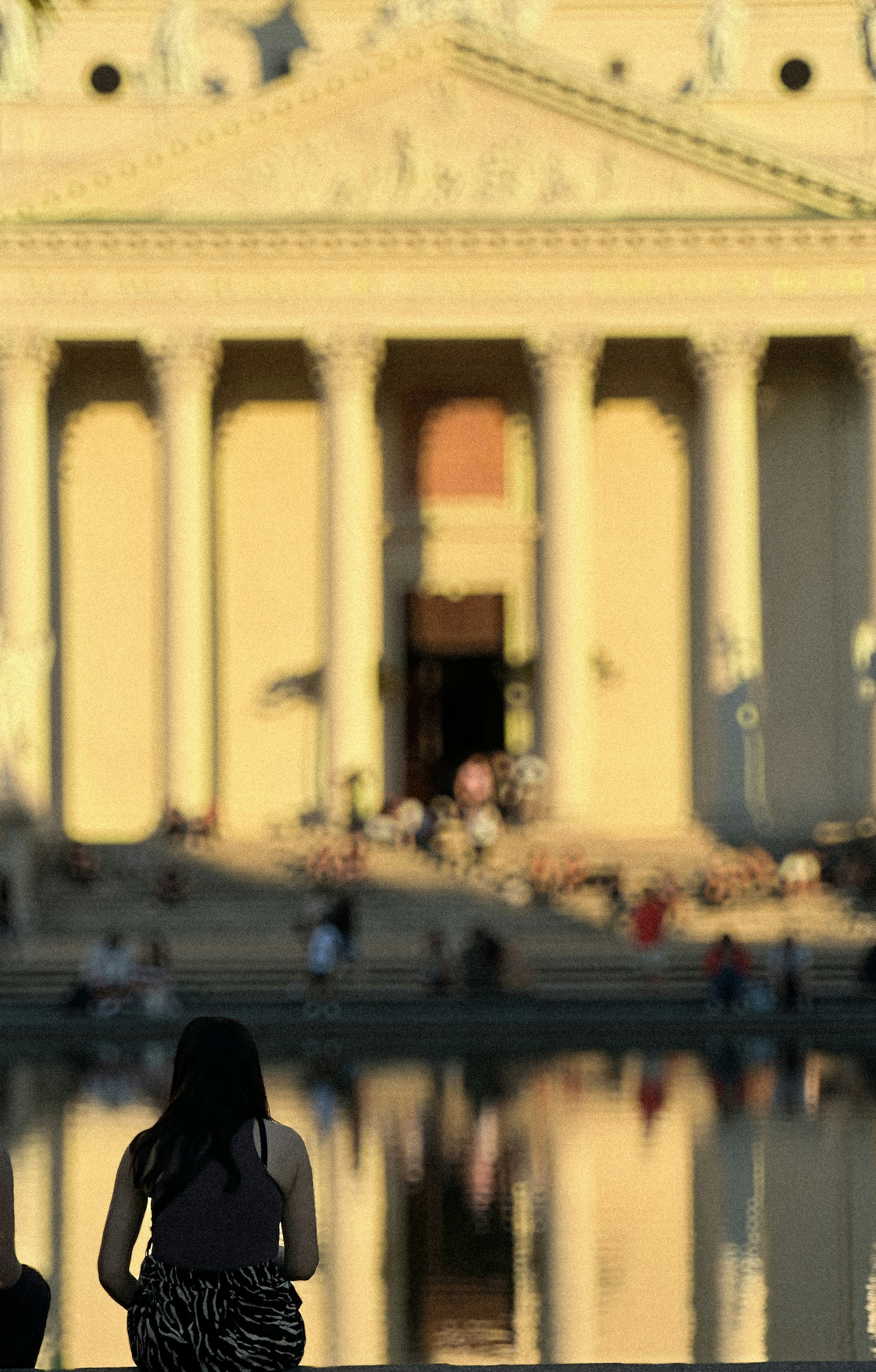Zwei Personen sitzen auf einer Bank vor einem Gebäude