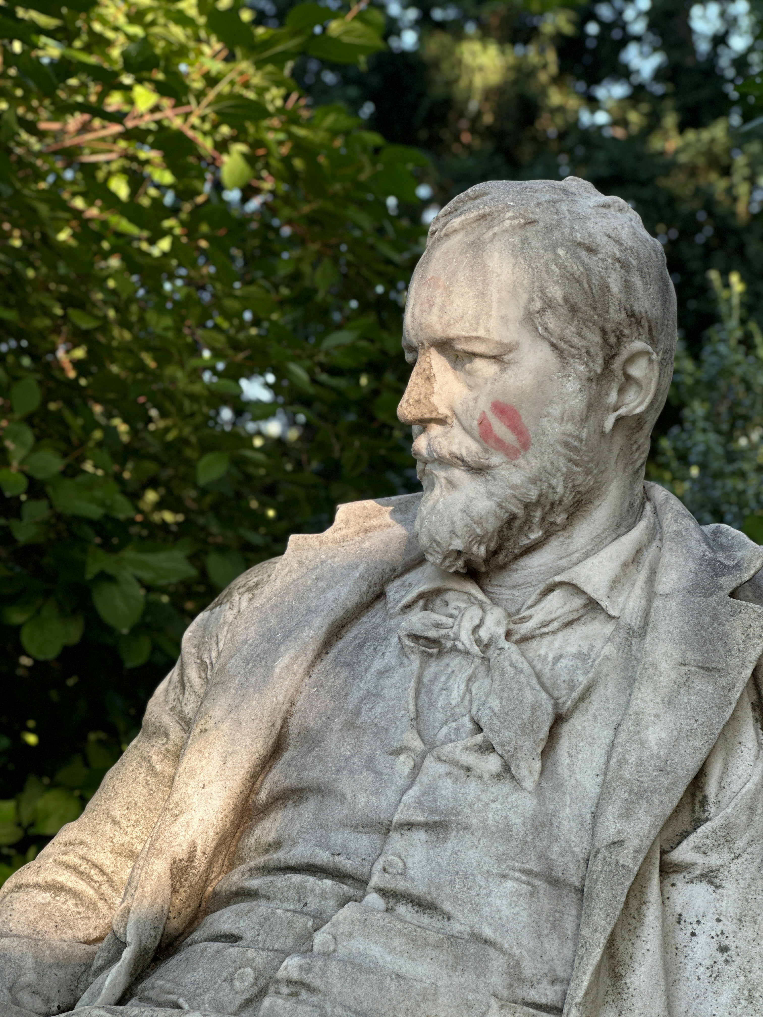 A statue of a man sitting in a park