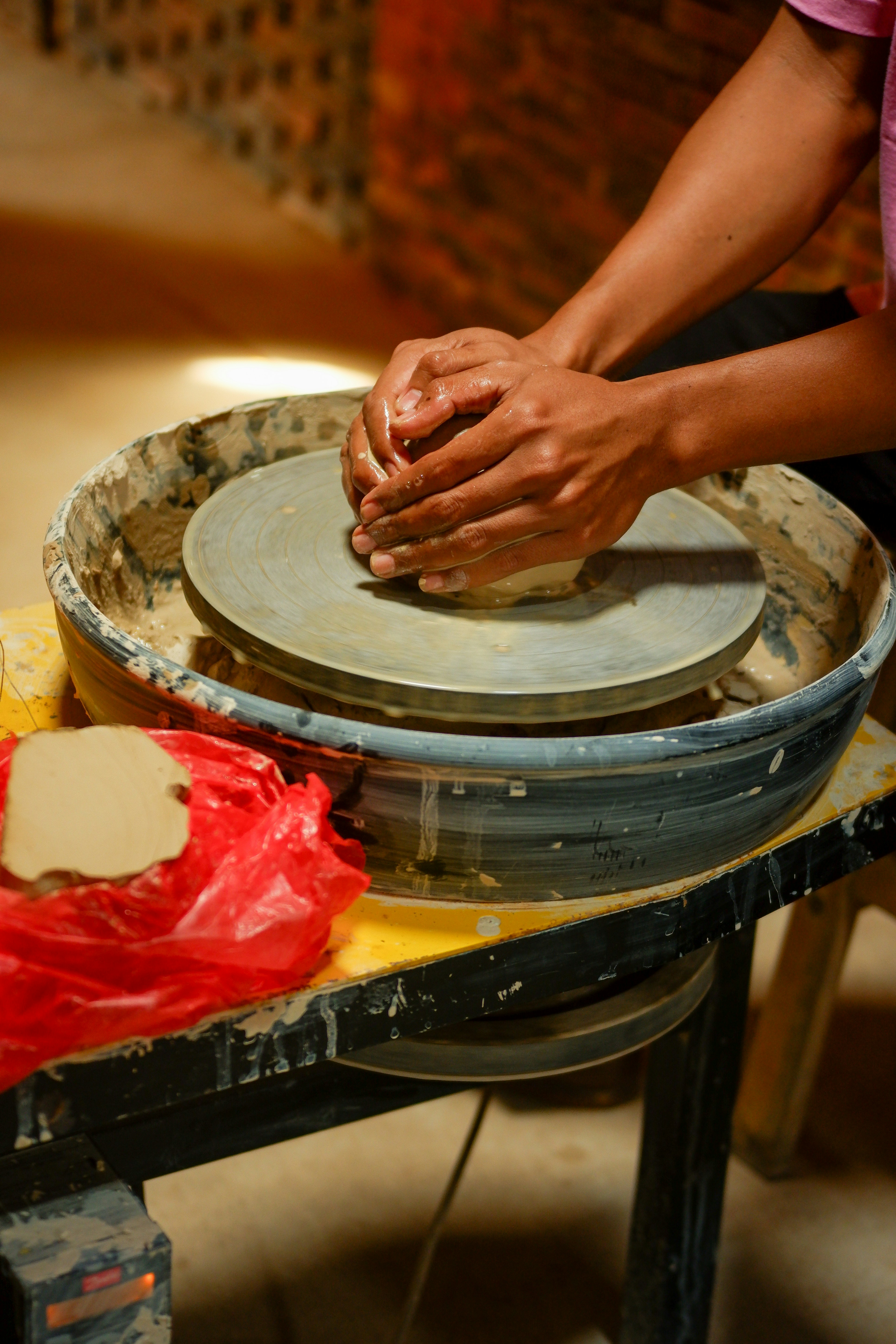 A woman is working on a pottery wheel