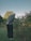 A man standing in the grass next to a bush