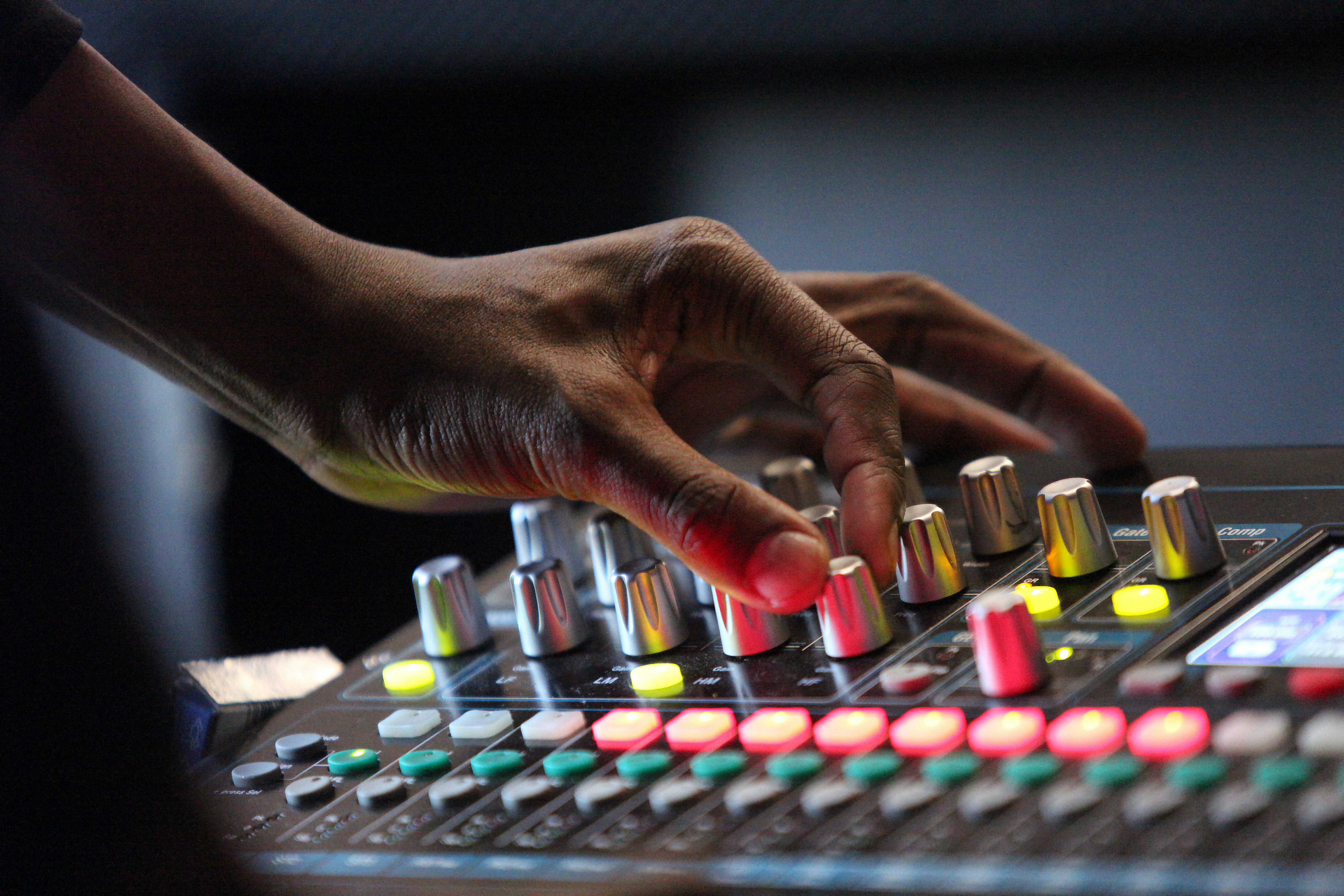 A person is using a sound mixing console