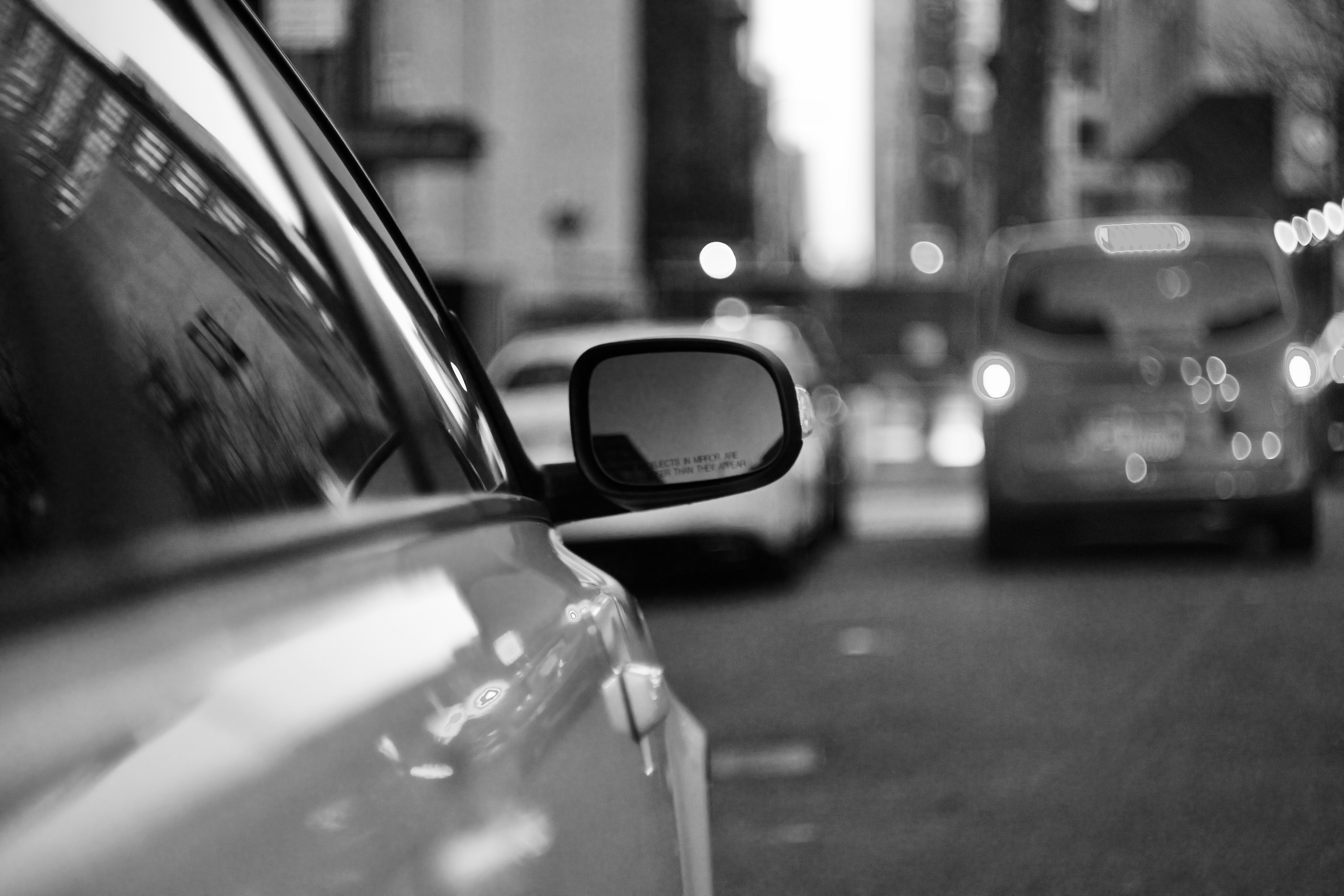 A black and white photo of cars on a city street
