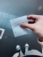 A person holding a ticket in their hand