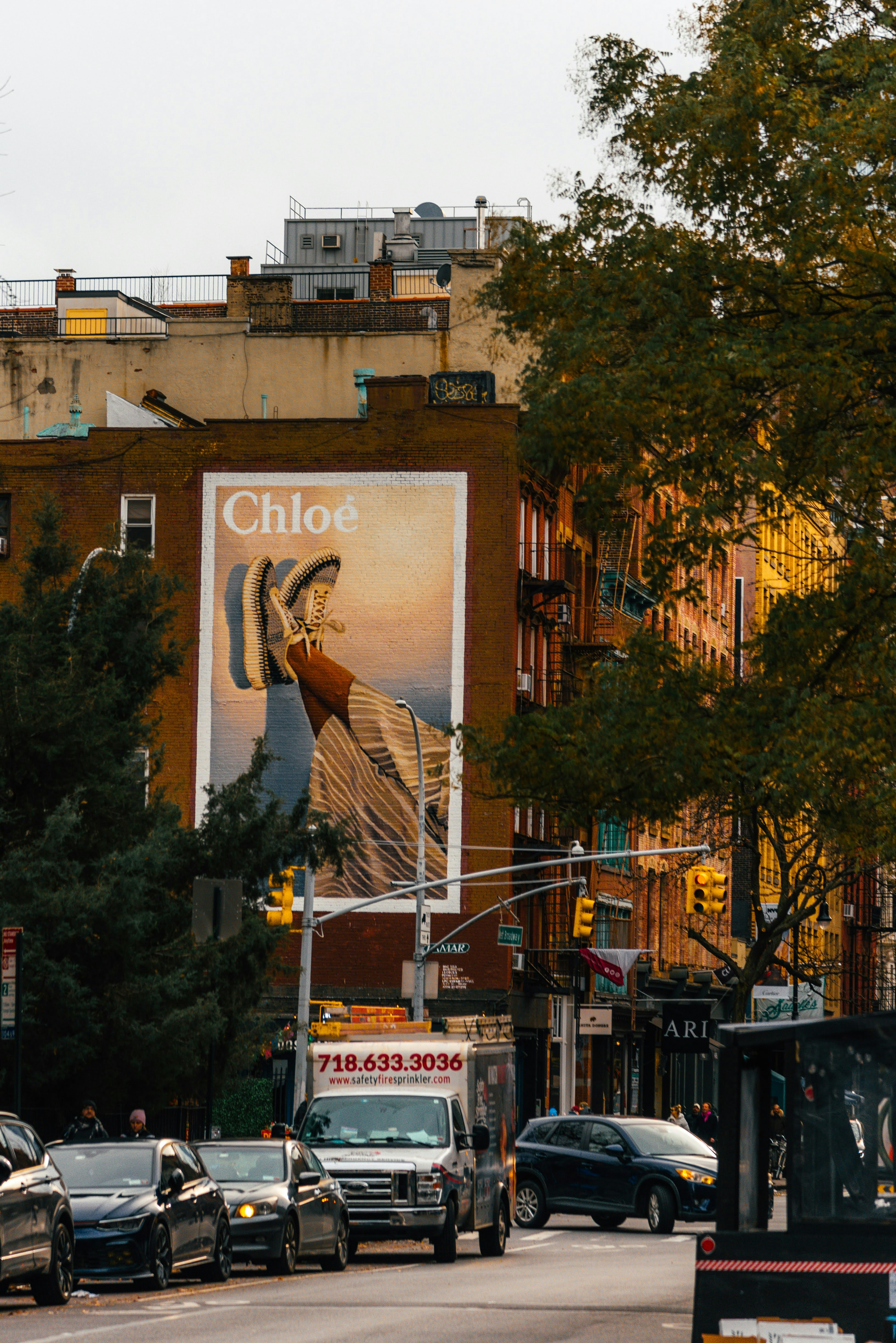 A city street filled with traffic next to tall buildings