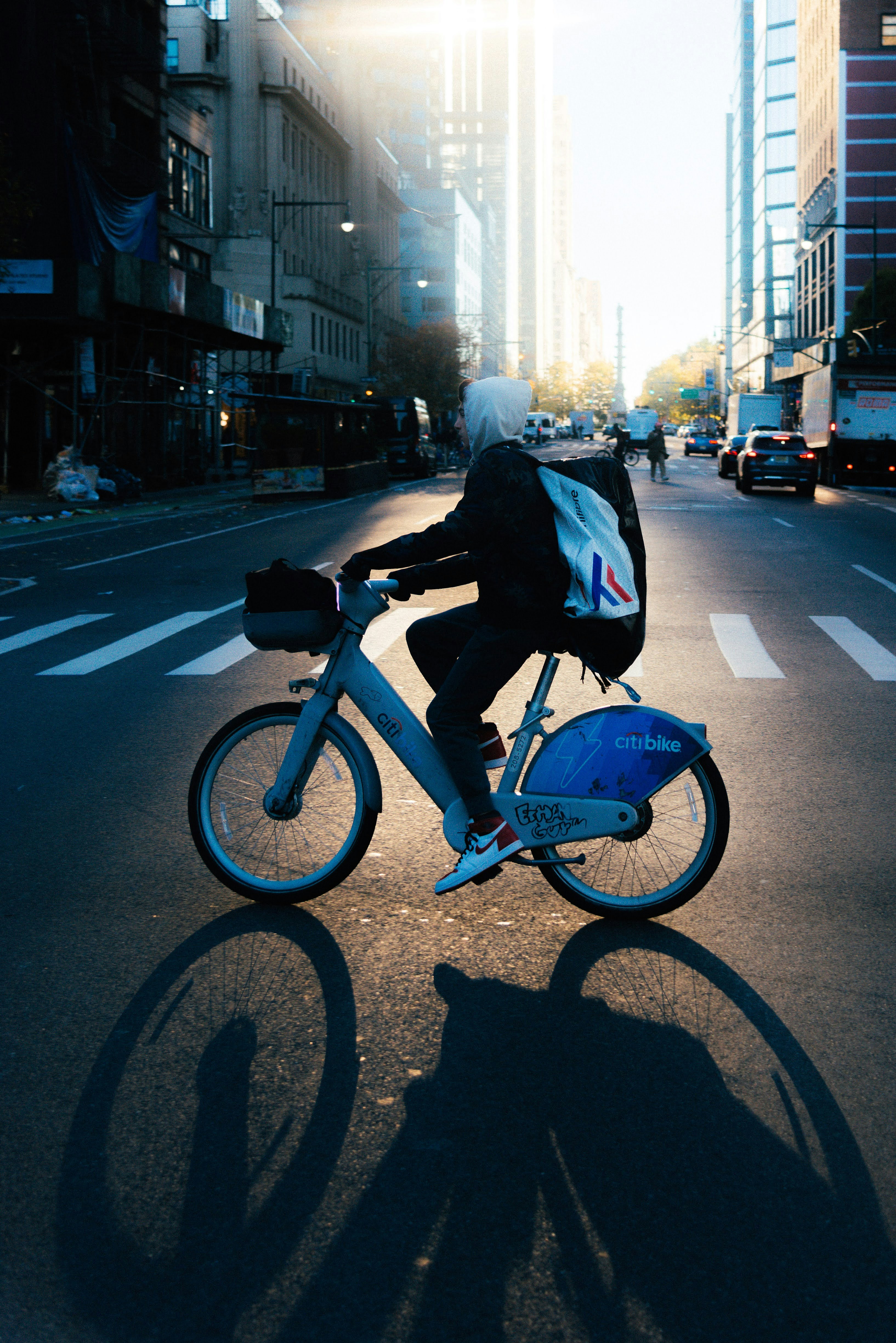 A man riding a bike down a street next to tall buildings