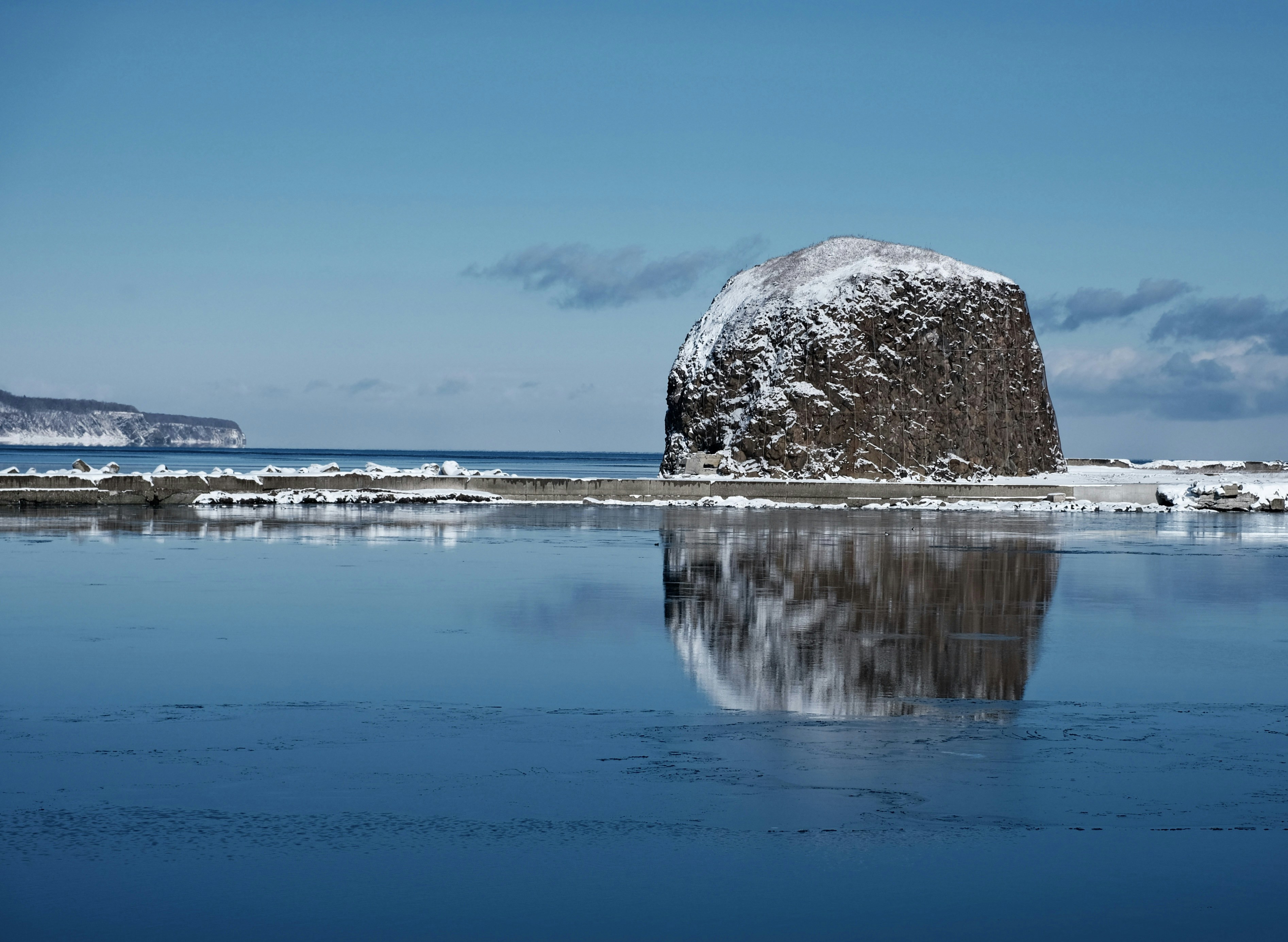 A large rock sitting in the middle of a body of water