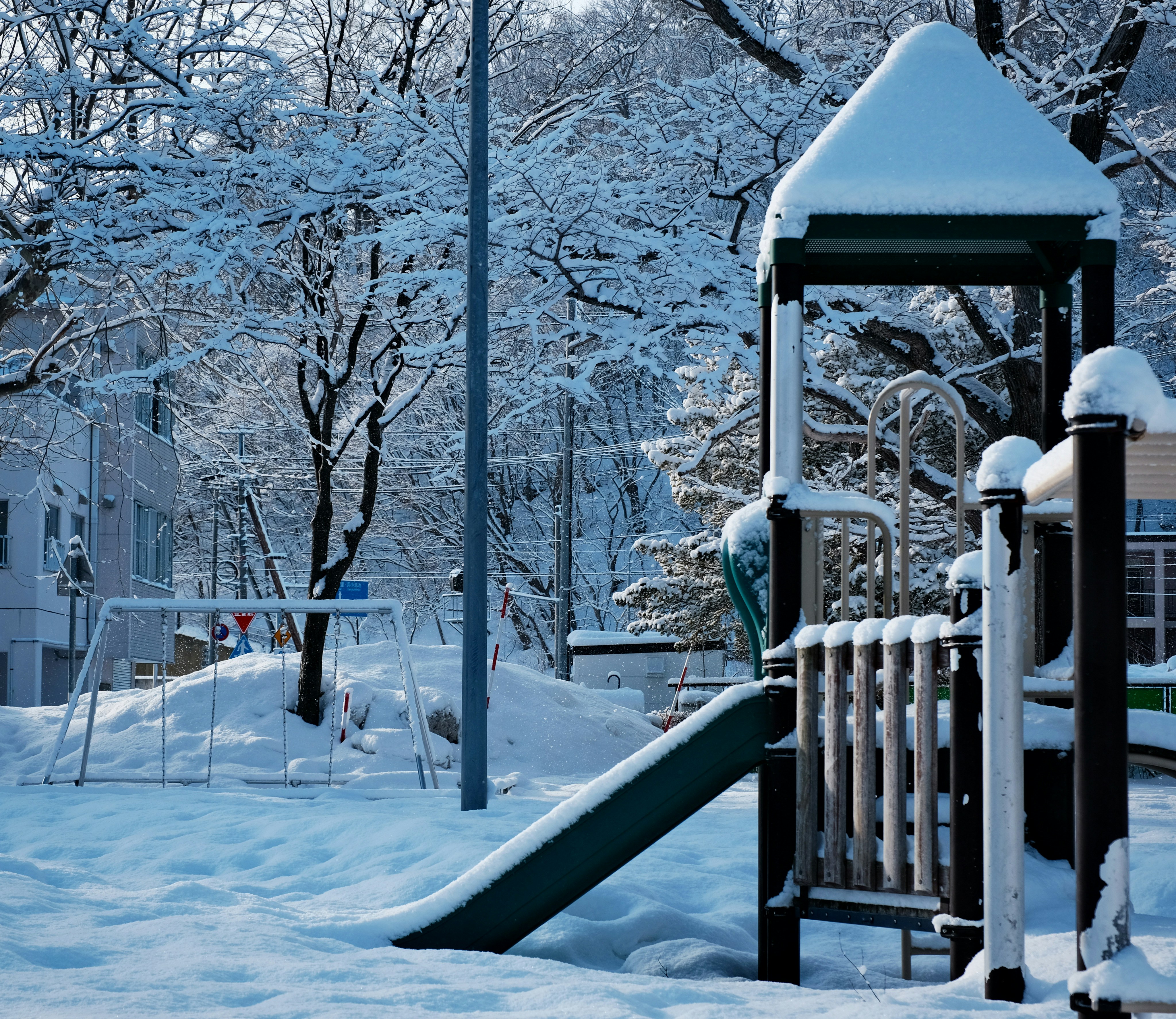 A playground in a park covered in snow