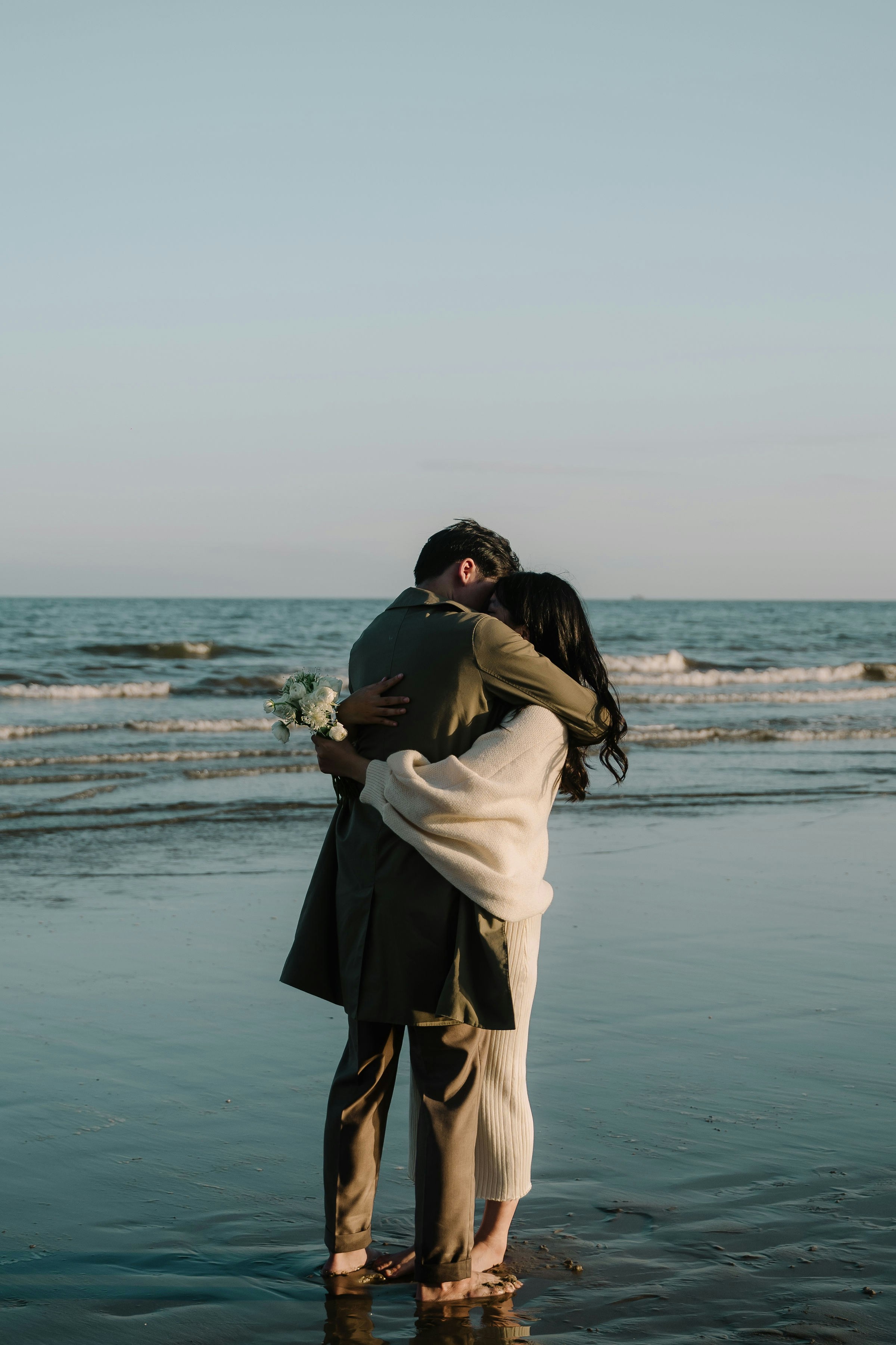 A man and woman embracing on the beach