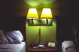 A hotel room with two beds and a night stand