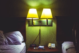 A hotel room with two beds and a night stand