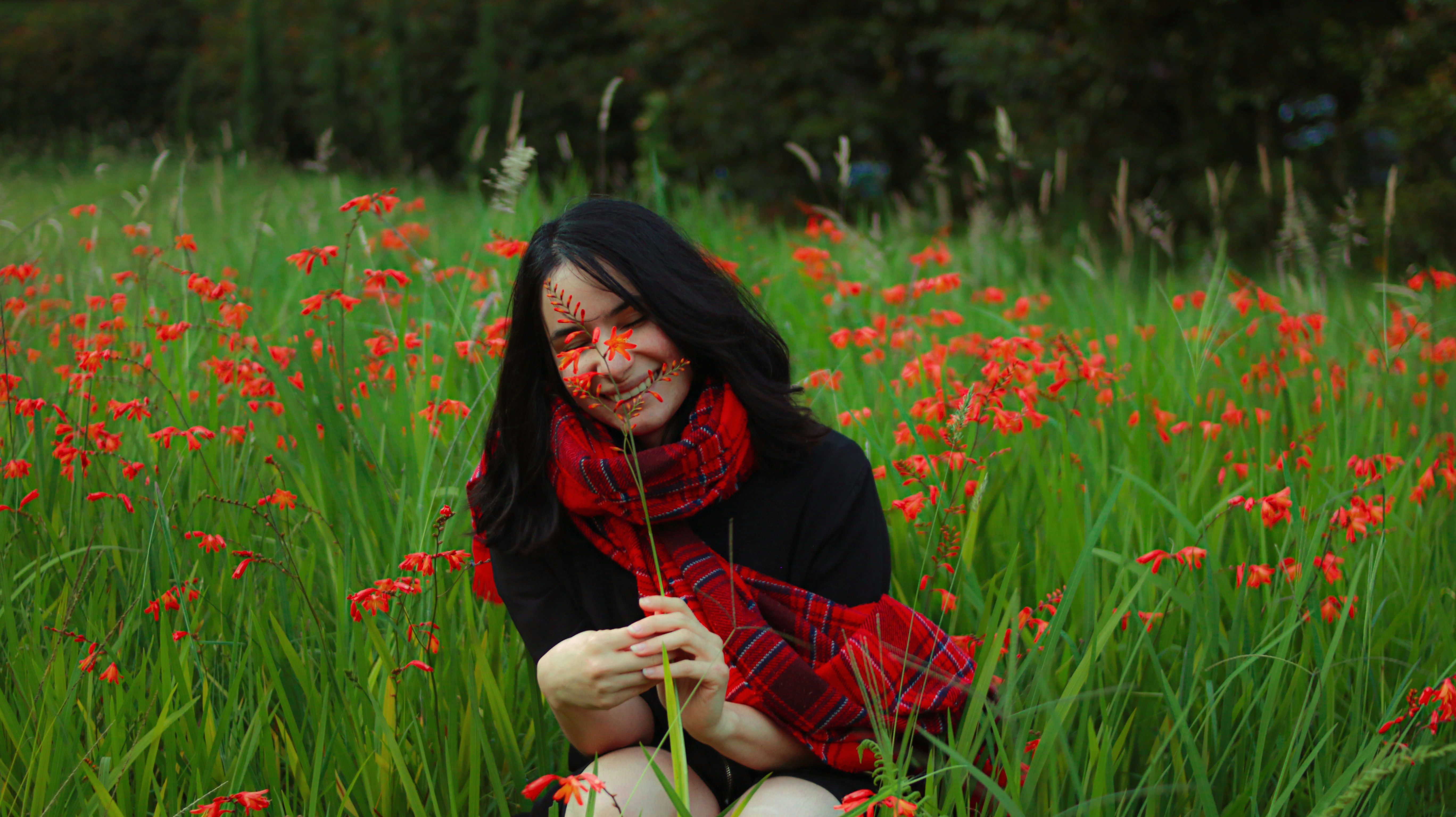 A woman kneeling in a field of flowers