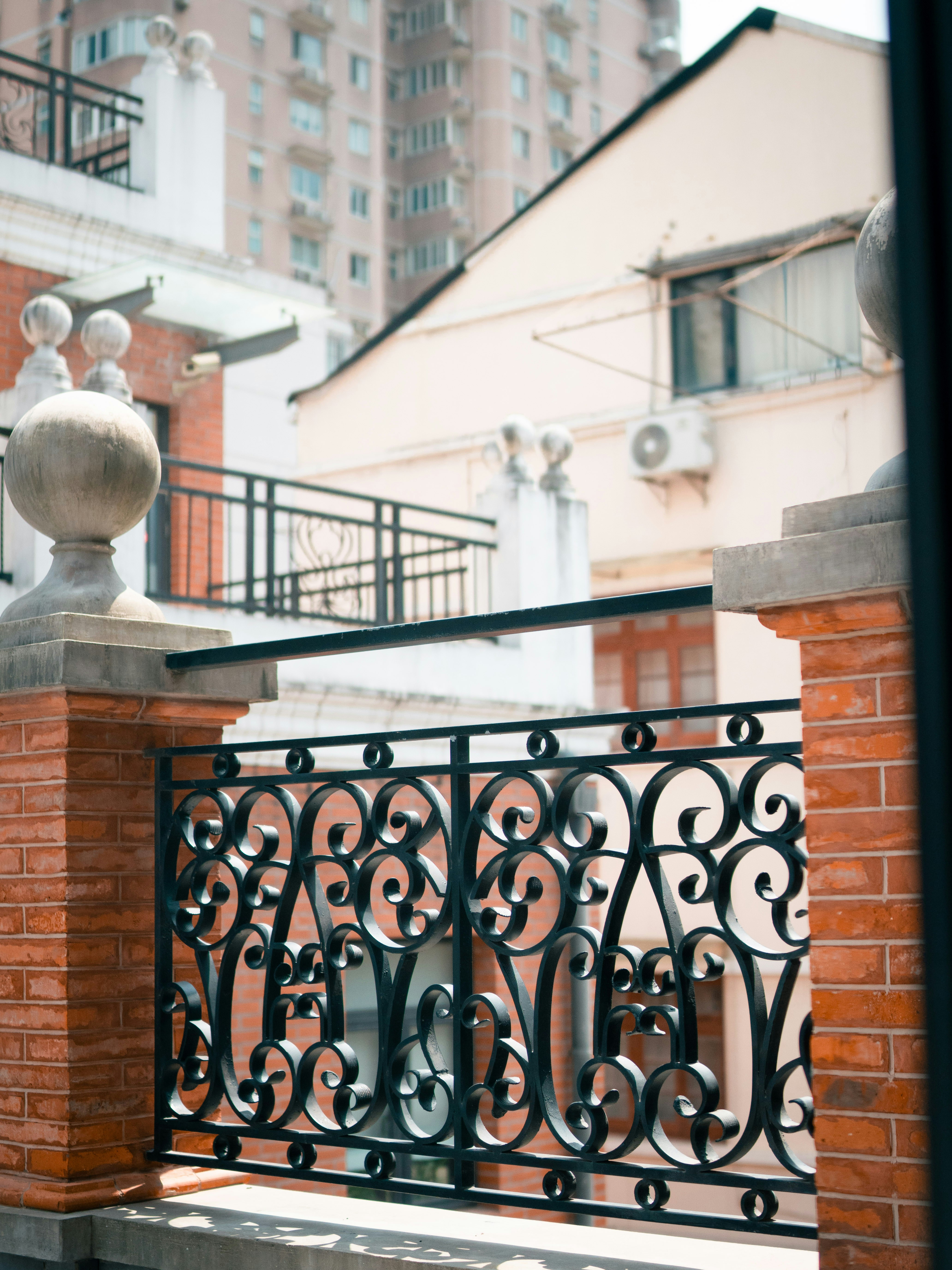 A balcony with a brick wall and wrought iron railing photo – Free ...