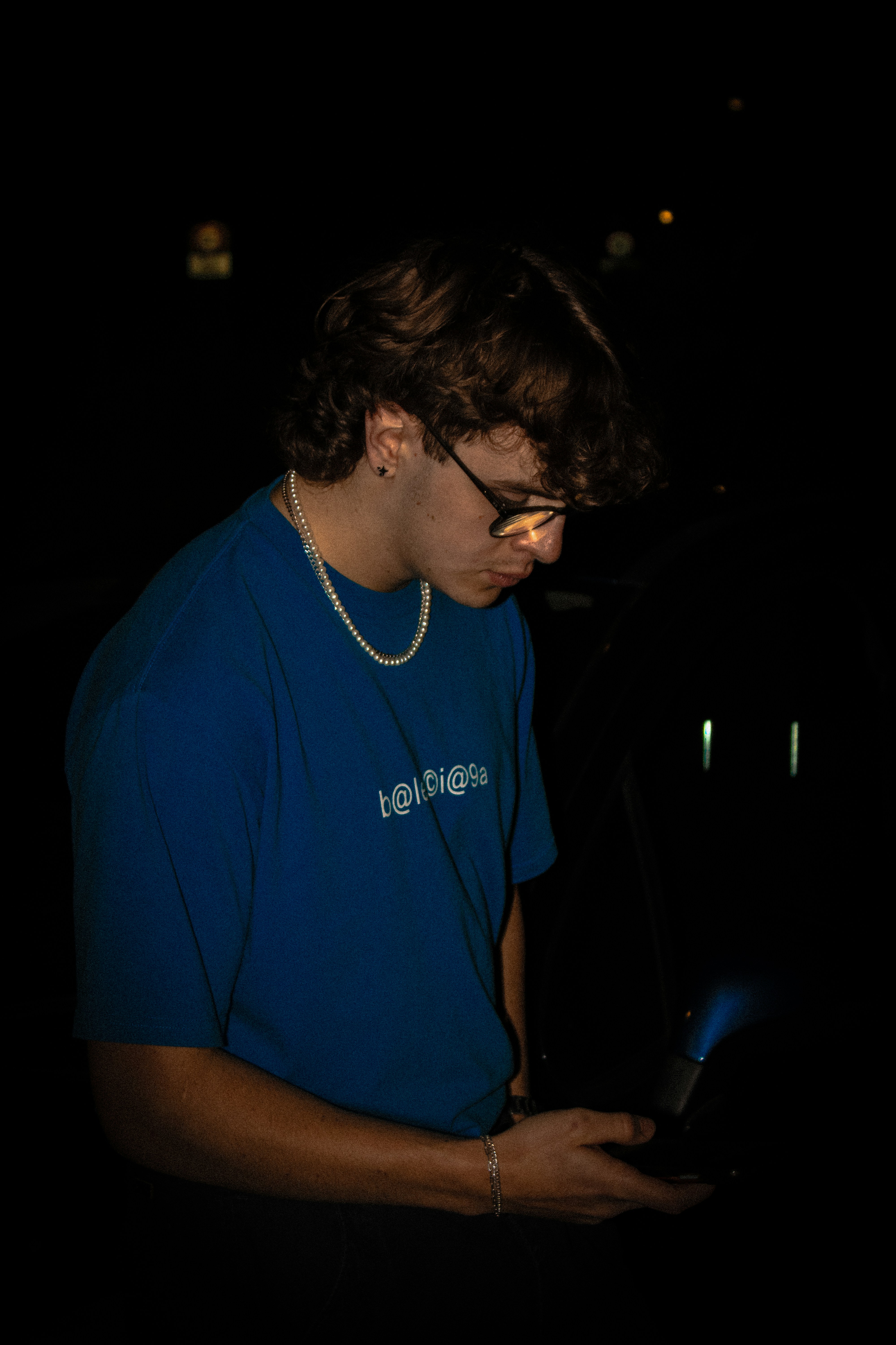A man in a blue shirt looking at a cell phone