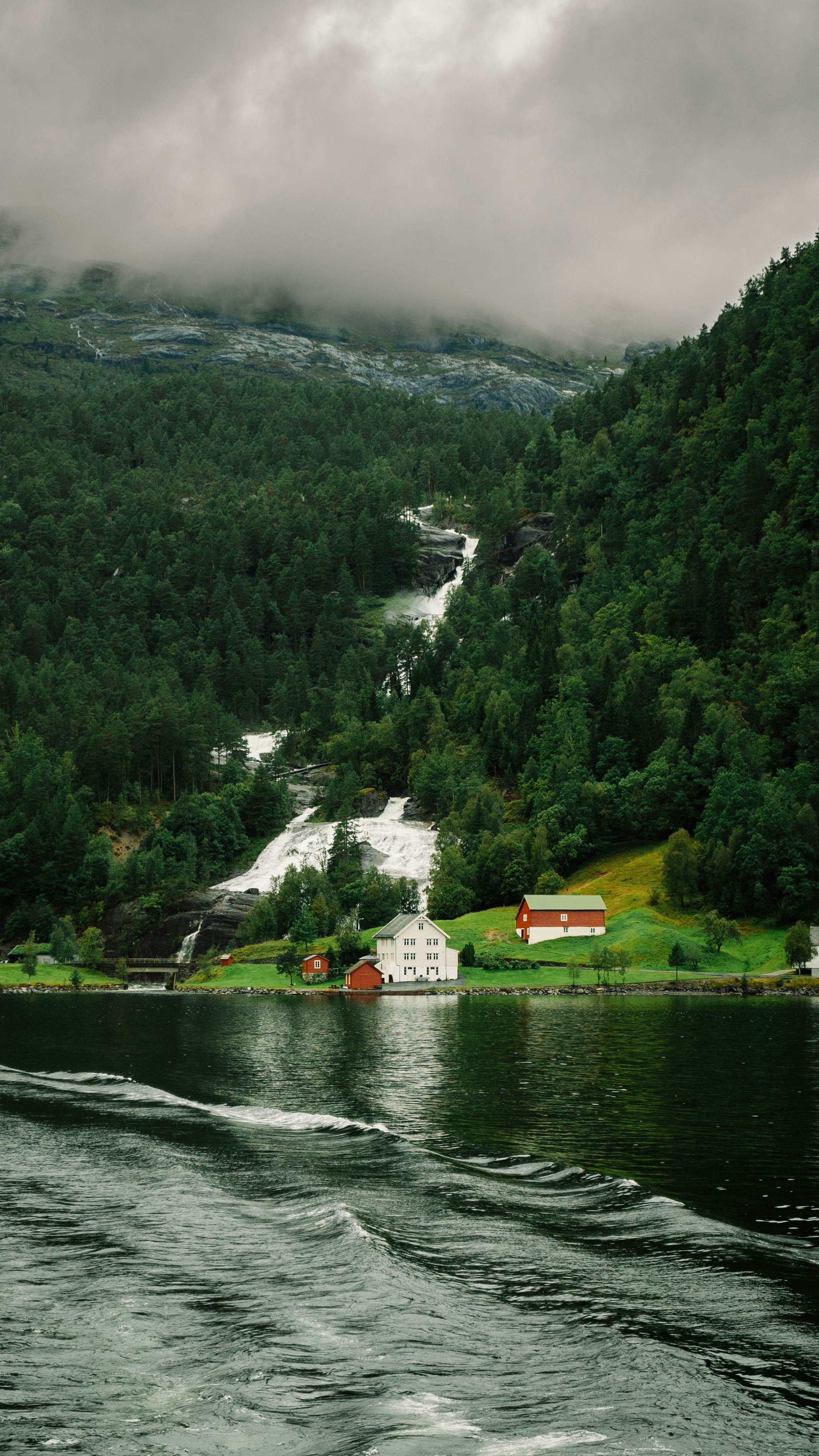 Ein Boot, das einen Fluss entlang eines üppig grünen Hügels fährt