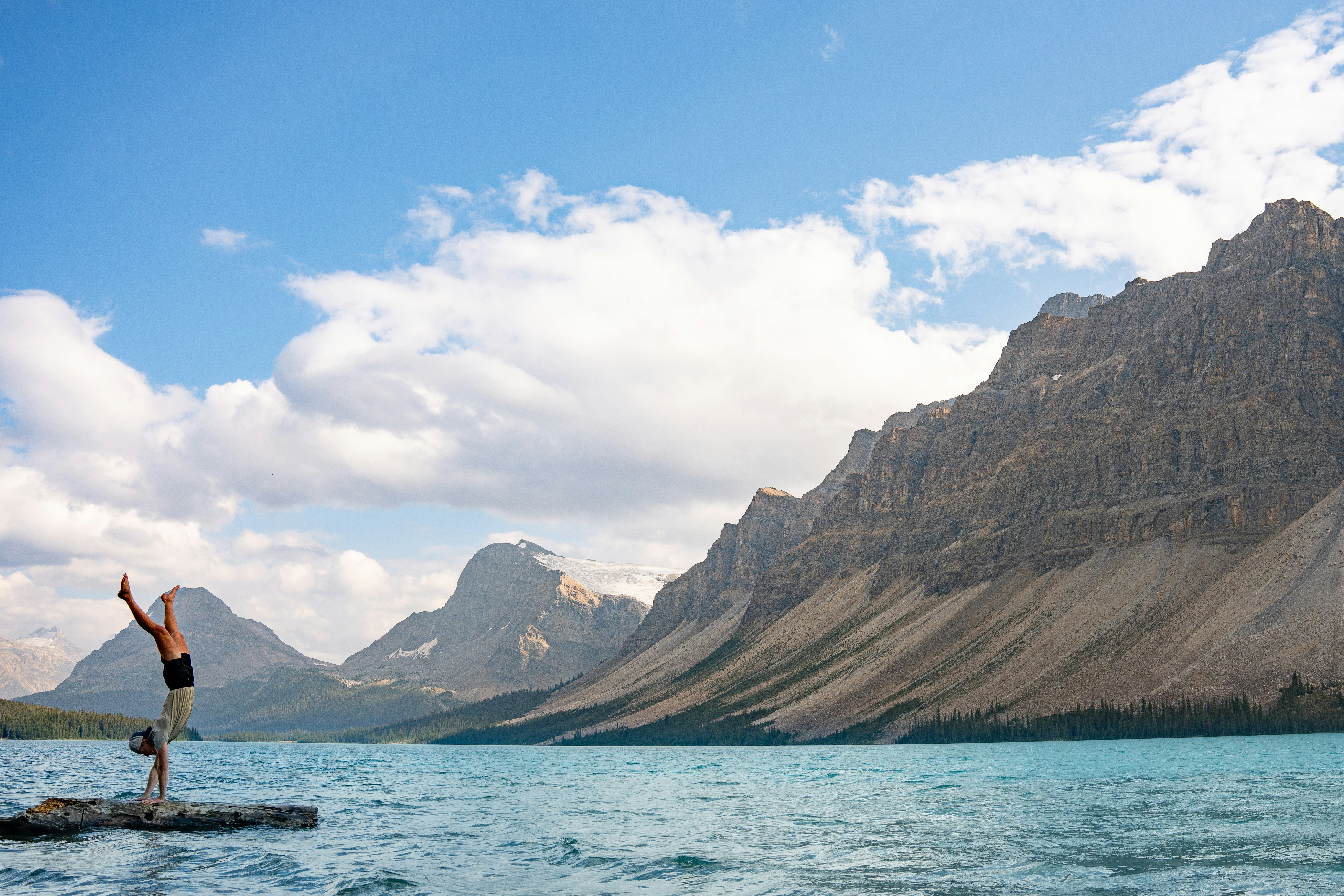 A man standing on a rock in the middle of a lake, Bow Lake