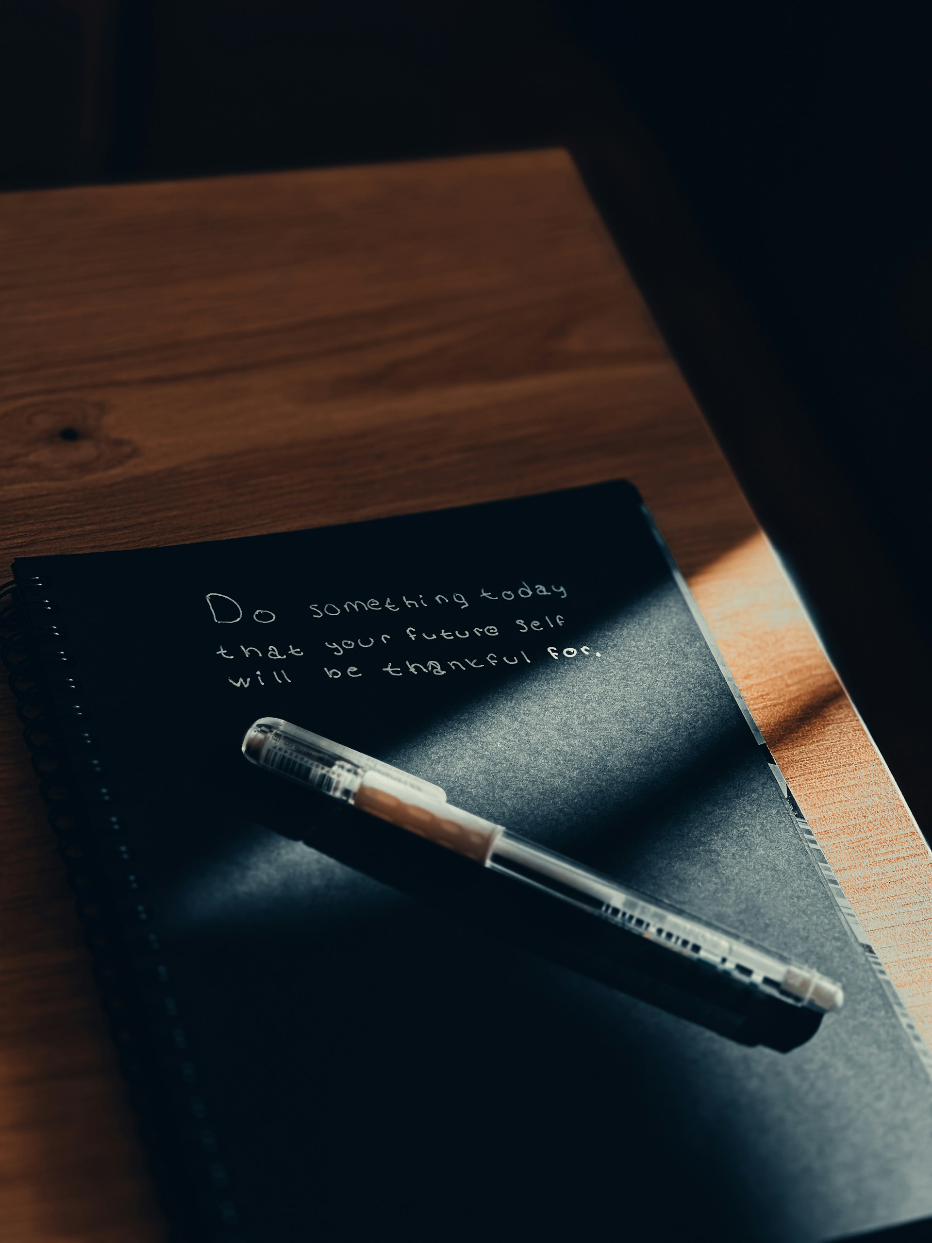 A notebook with a pen sitting on top of it