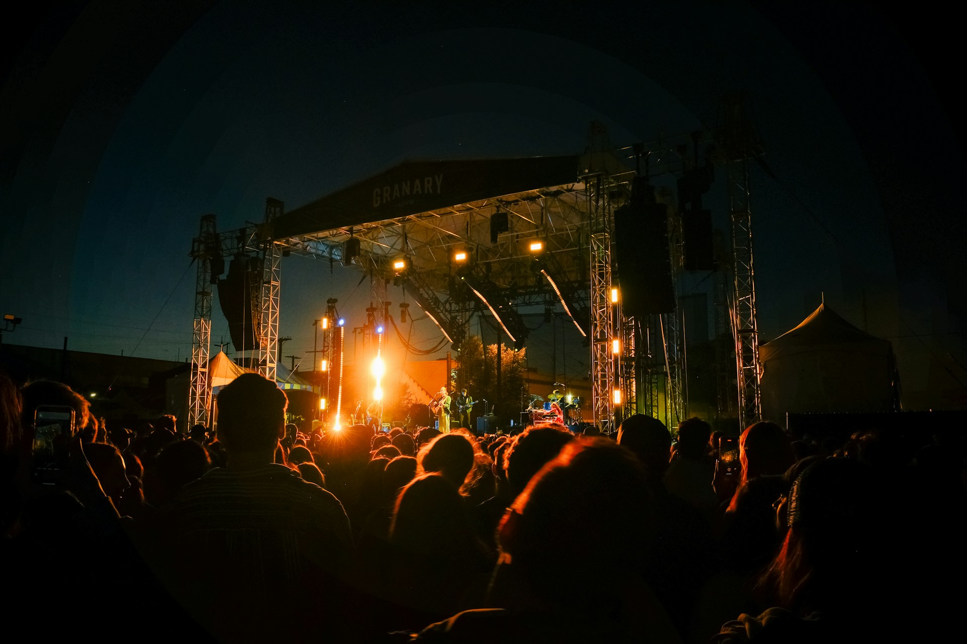 A crowd of people standing around a stage at night