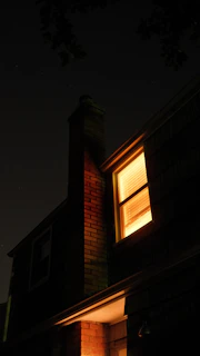 A house with a lit up window at night