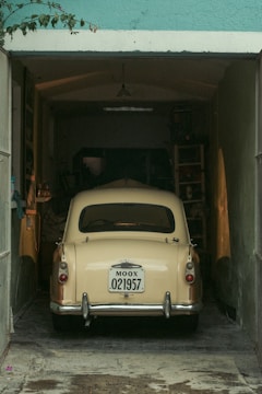An old car is parked in a garage