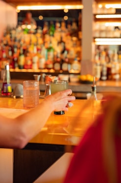 A woman sitting at a bar with a drink in her hand