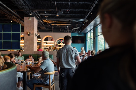A group of people sitting at tables in a restaurant