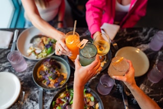 A group of women sitting around a table with vegan food and drinks - veto vote