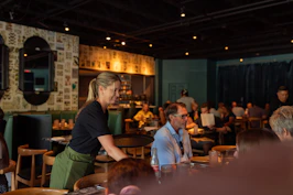 A group of people sitting at tables in a restaurant