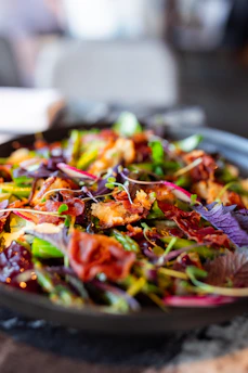 A plate of bacon salad with red onions and green peppers