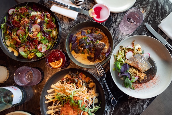 A table topped with lots of plates of food
