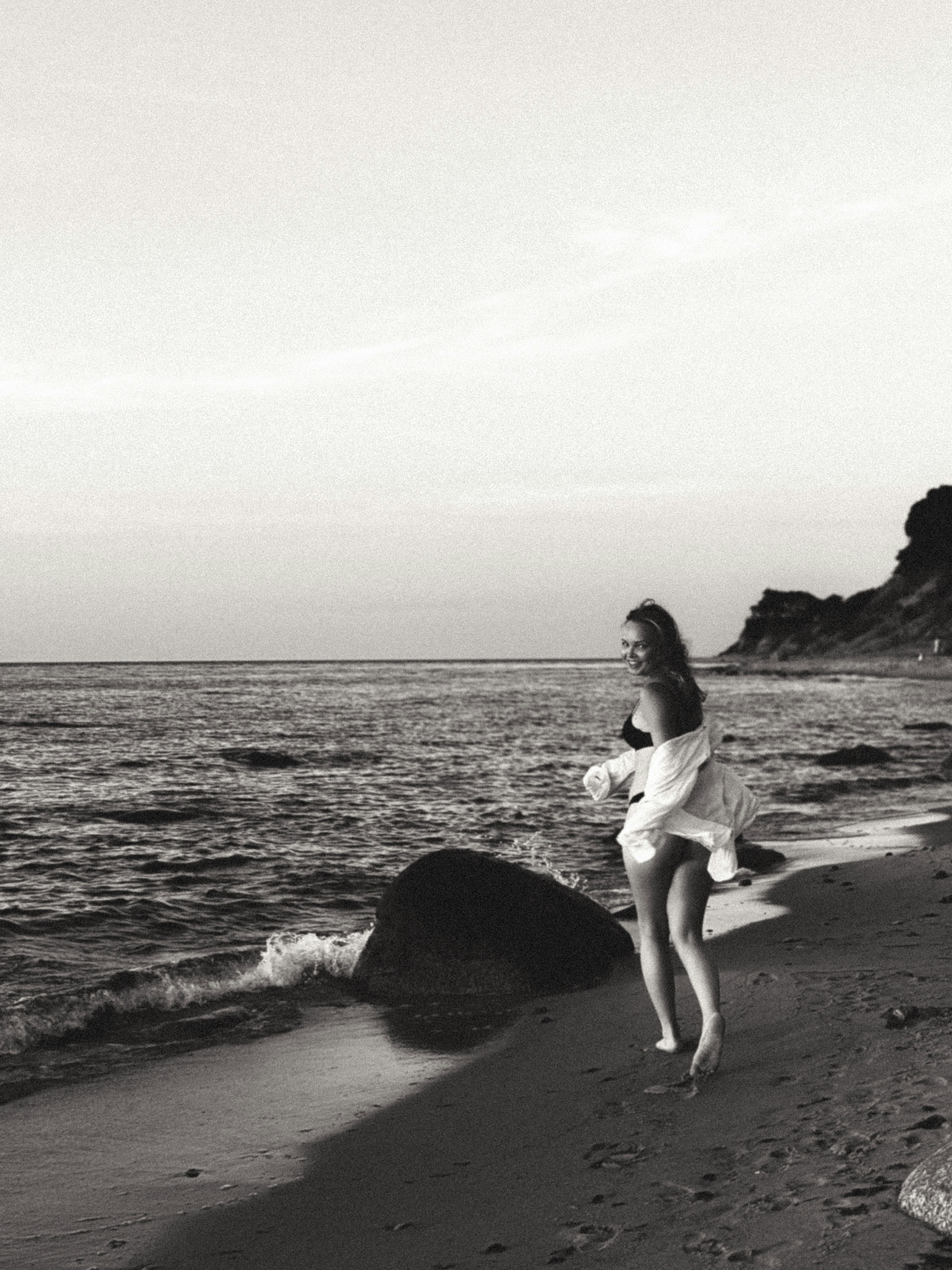 A woman running on a beach near the ocean